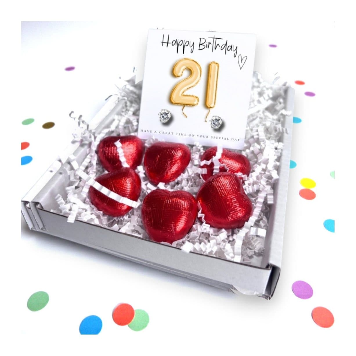 Cubic zirconia stud earrings and red chocolate hearts on a gold balloons card
