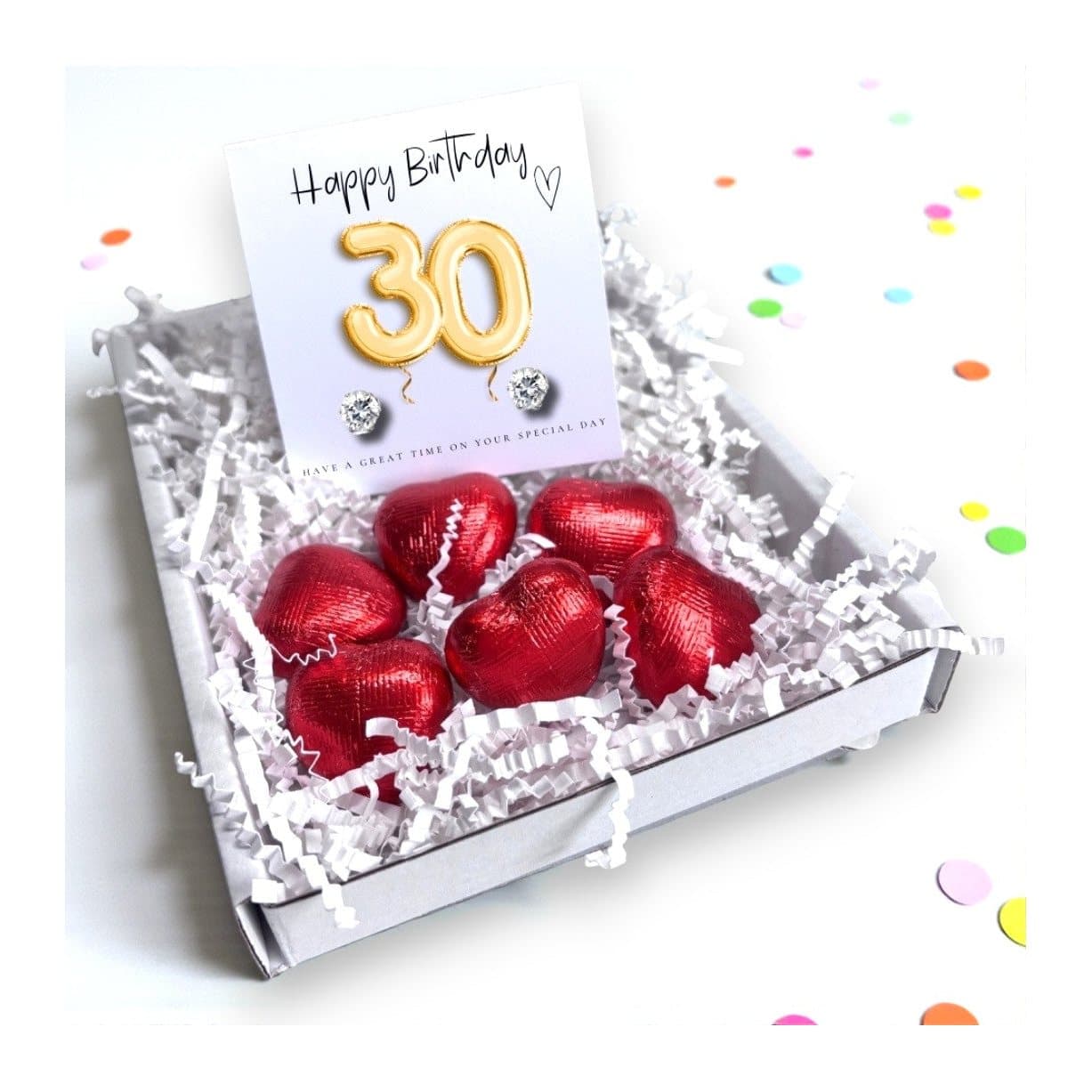 Cubic zirconia stud earrings and milk chocolate hearts with a gold balloons card