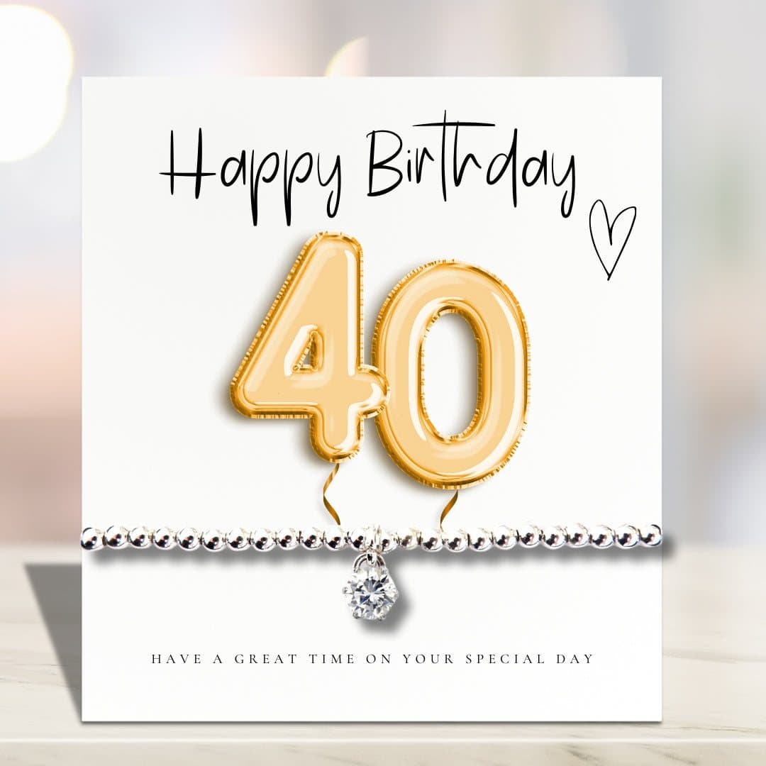 Silver stretch beaded bracelet with a cubic zirconia charm and a gold balloons card.