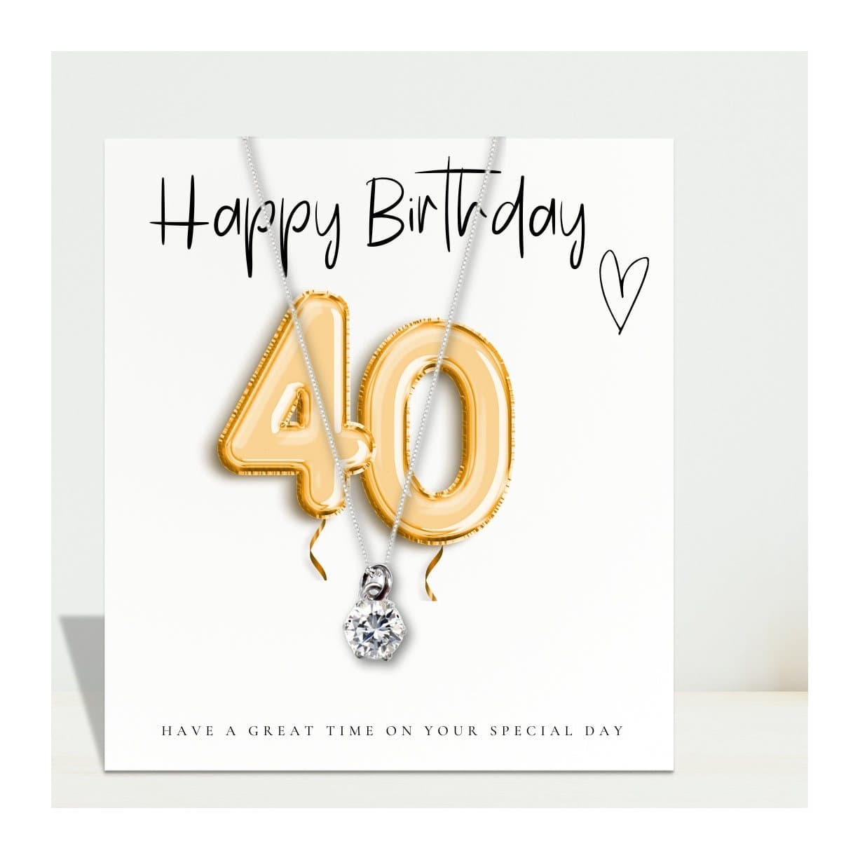 Silver necklace with a cubic zirconia charm and a gold balloons message card