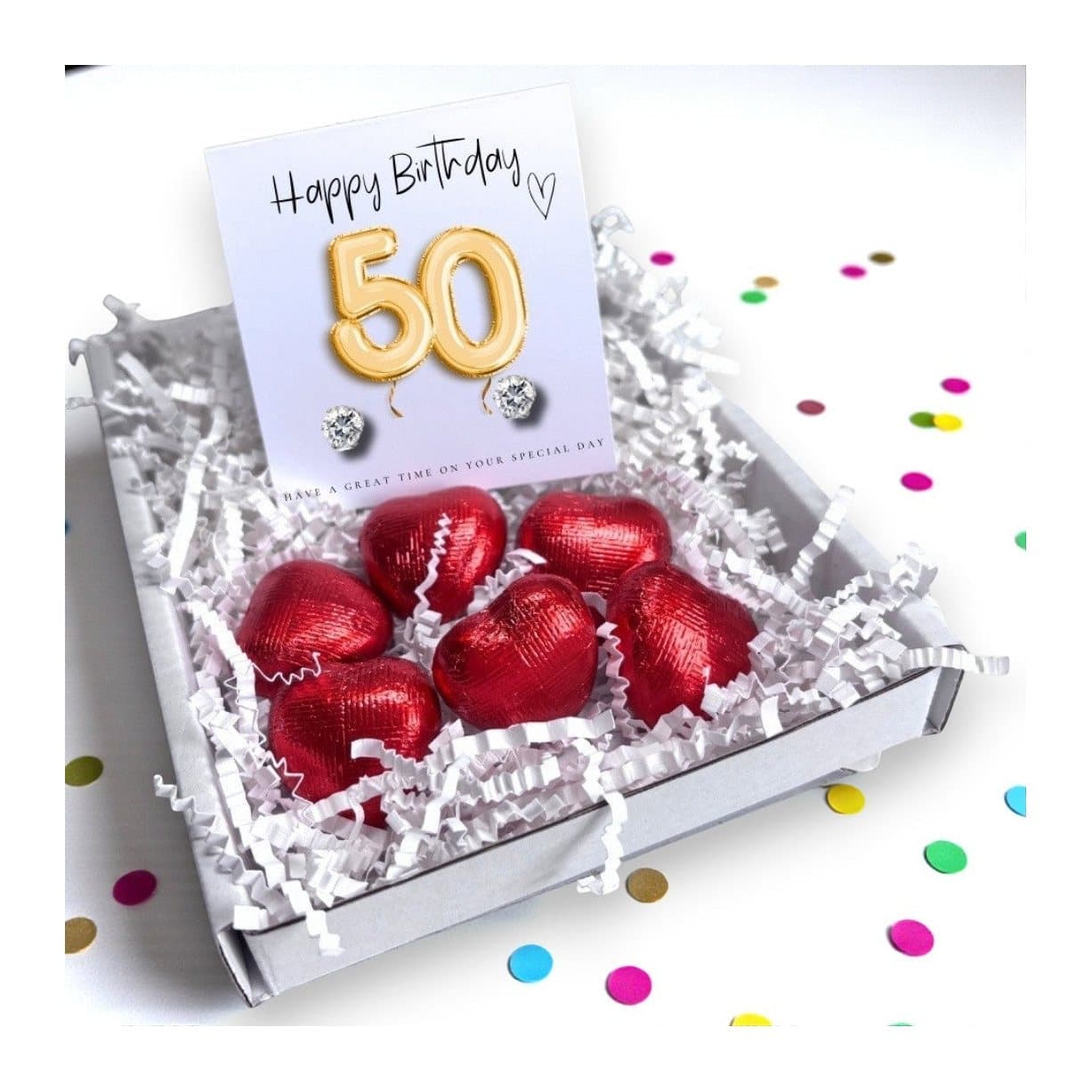 Cubic zirconia stud earrings and red foiled chocolate hearts on a gold balloons card