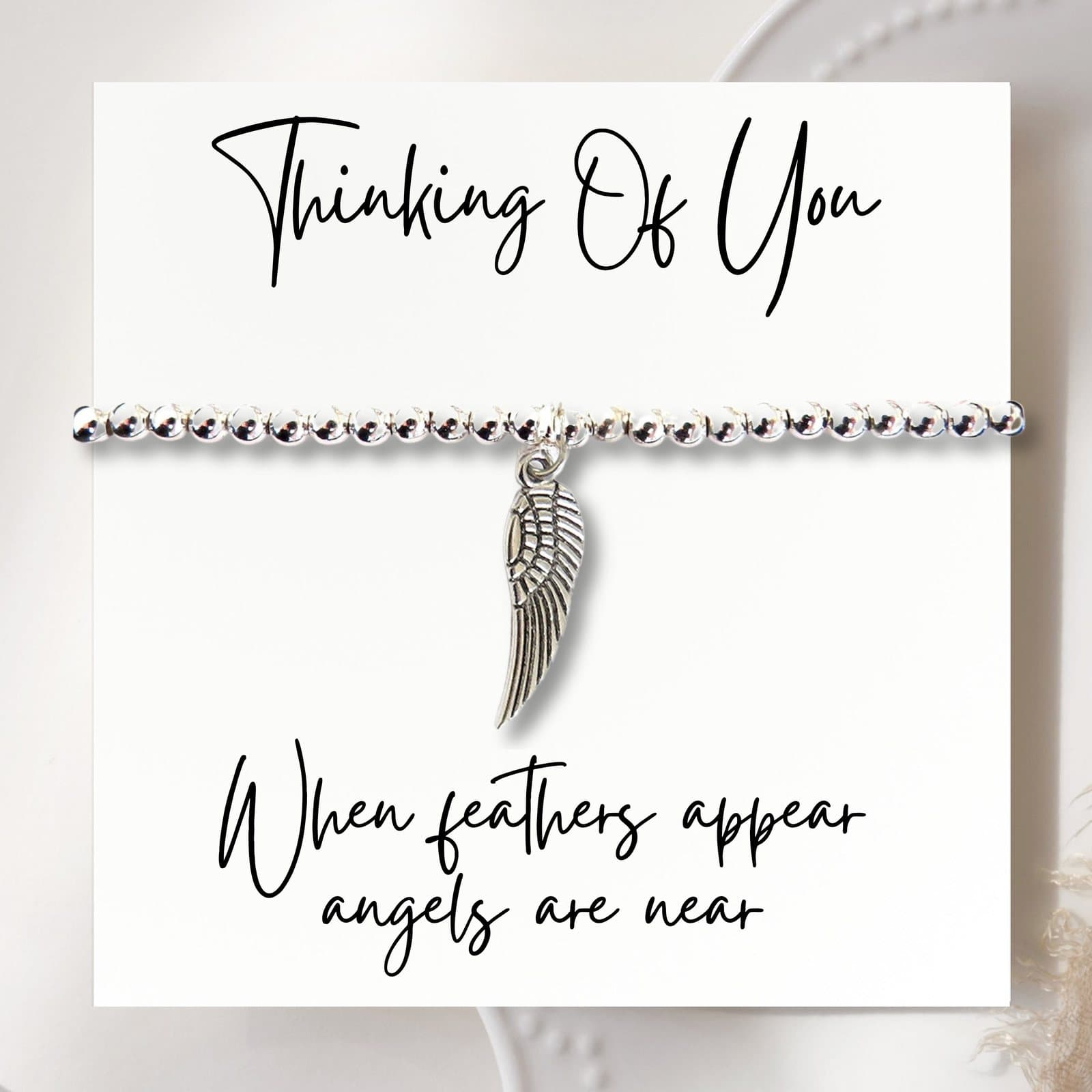 Silver beaded bracelet with an angel wing charm and a message card