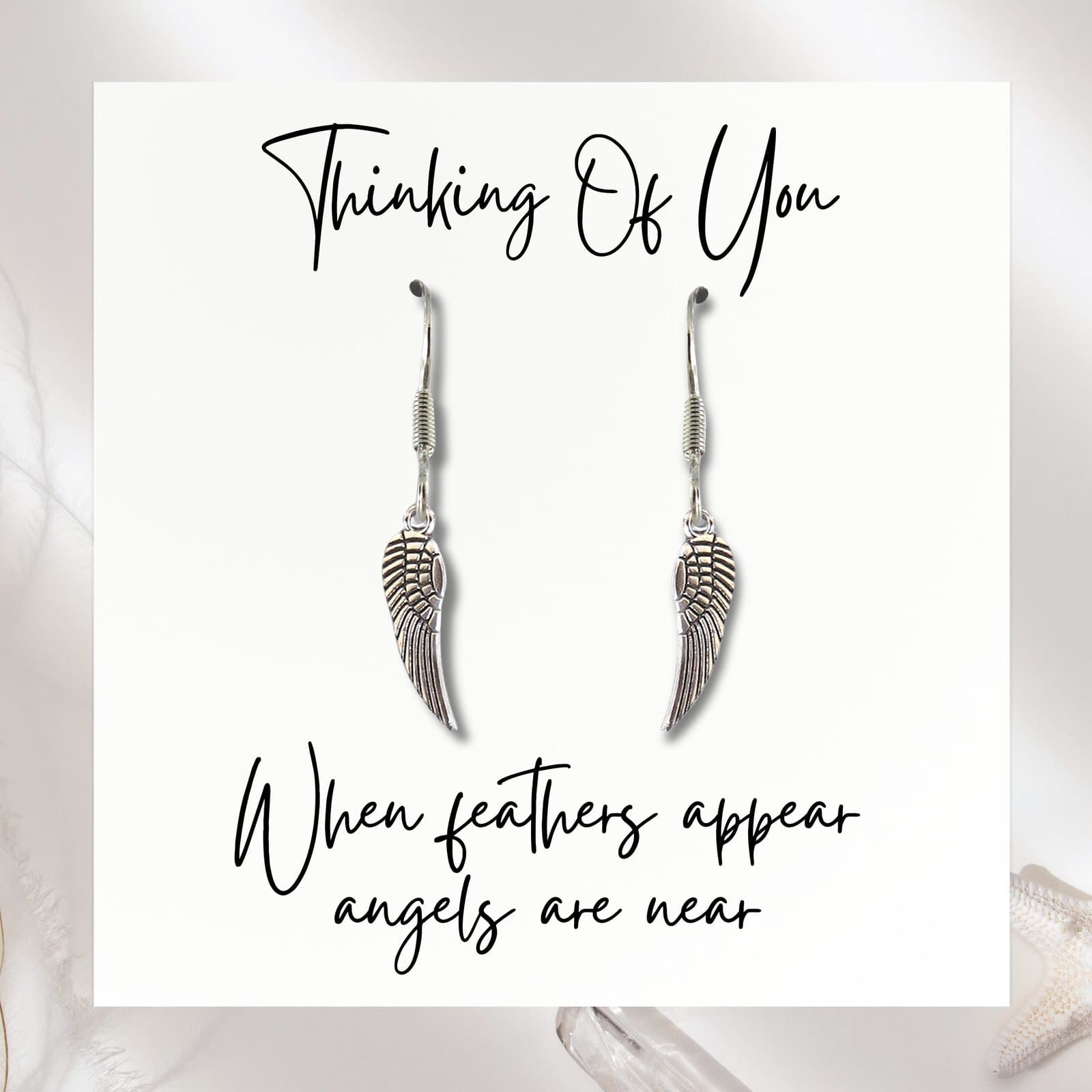 Pair of silver angel wing earrings with a message card