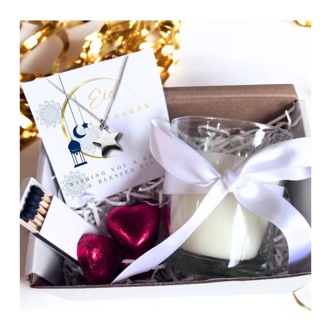 White candle in a clear glass jar with a moon design and Eid Mubarak