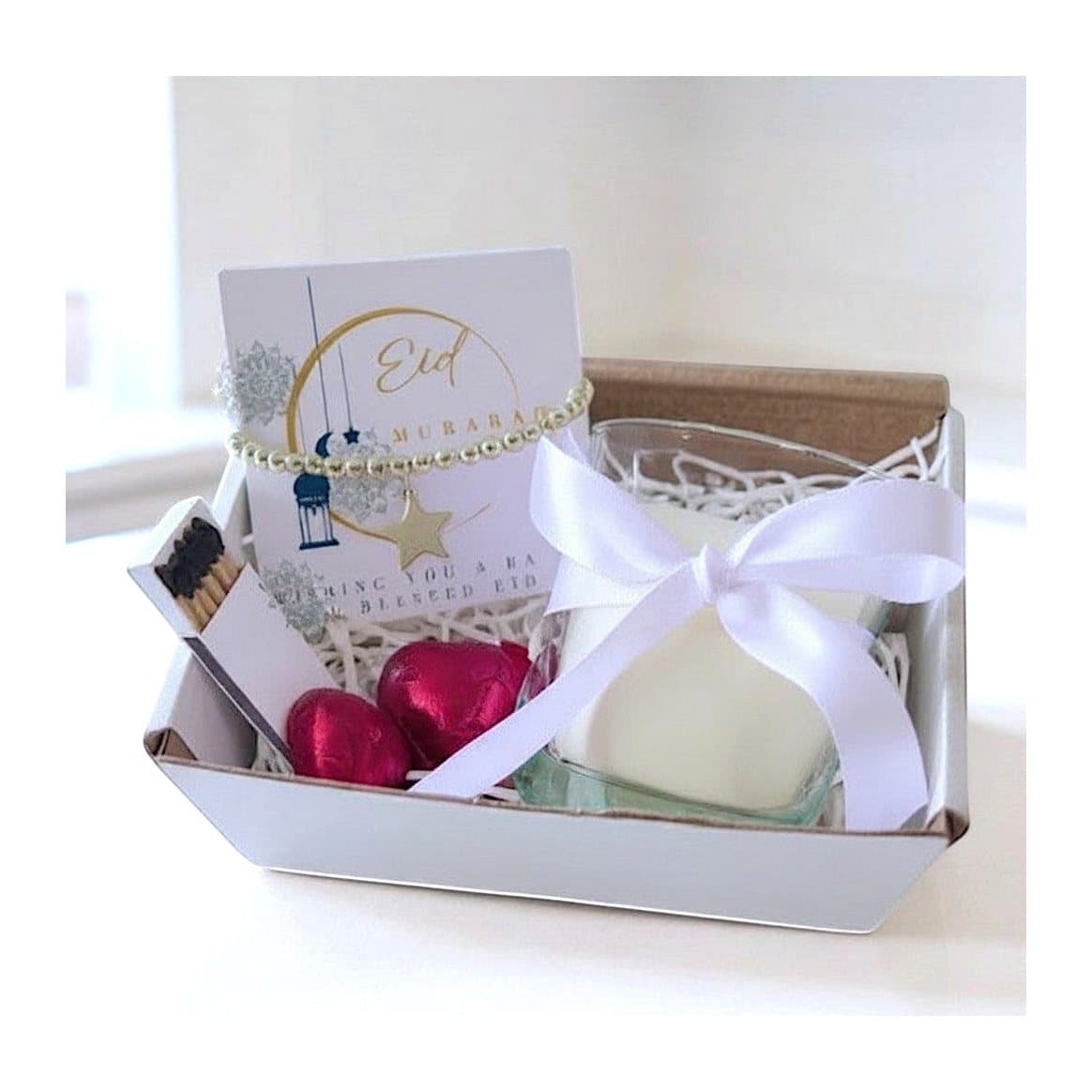 Eid Mubarak moon gift hamper with a candle, bracelet and red foiled chocolate hearts