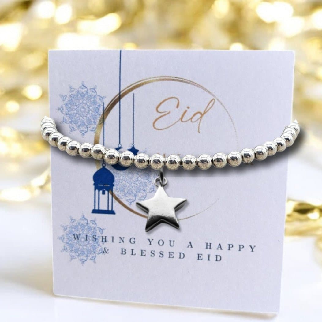 Silver star beaded bracelet on an Eid Mubarak card with a moon design