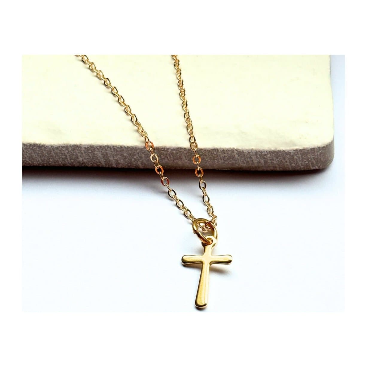 Gold cross charm necklace on a gold plated chain