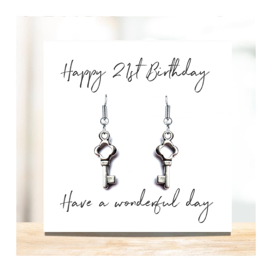 Silver drop earrings with a key charm and a Happy 21st Birthday card
