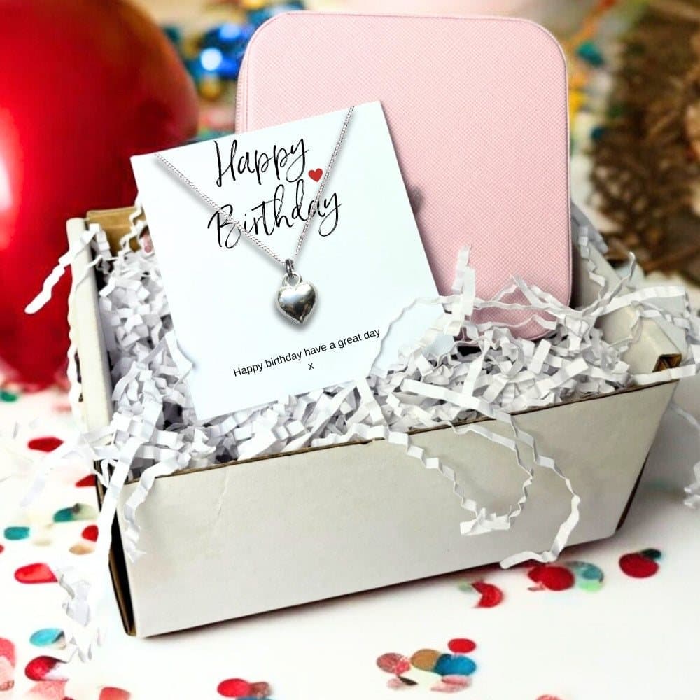 Silver heart charm necklace on a Happy Birthday card, with a pink square jewellery box