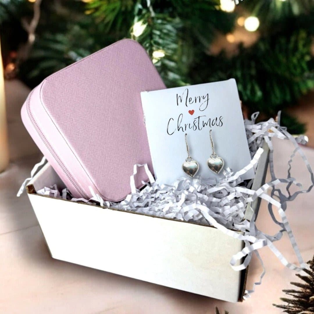 Silver heart drop earrings, a pink jewellery box and a Merry Christmas card.