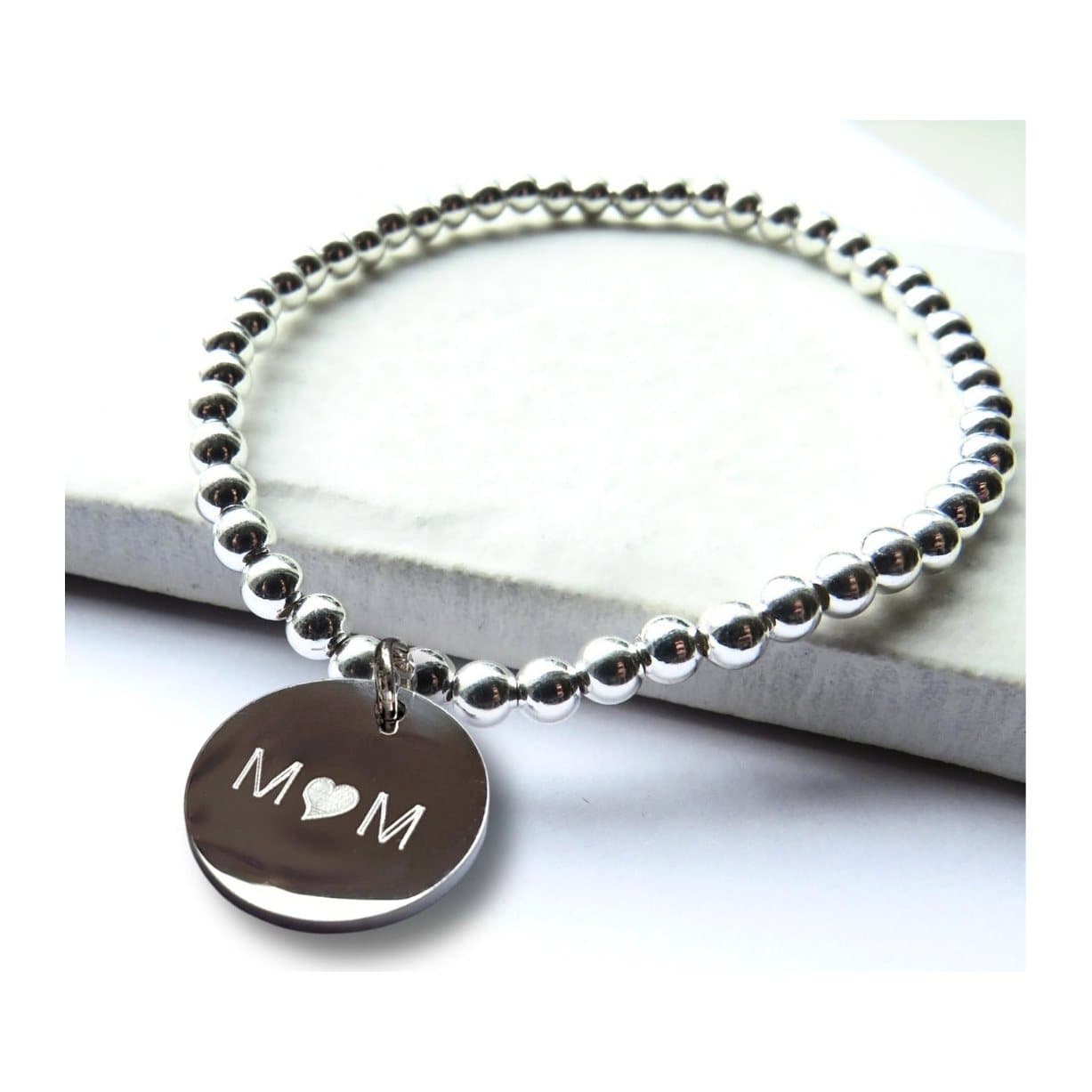 Silver beaded bracelet with a disc engraved Mum, the u replaced by a heart