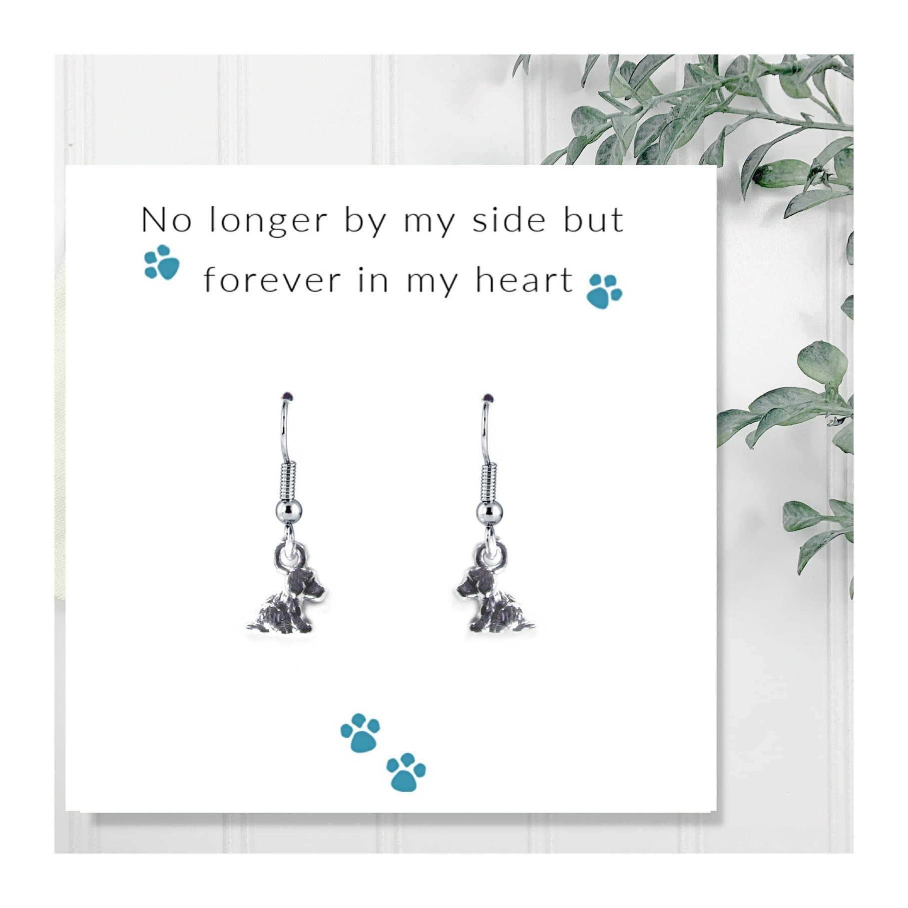 Tiny puppy dog drop earrings presented on a message card