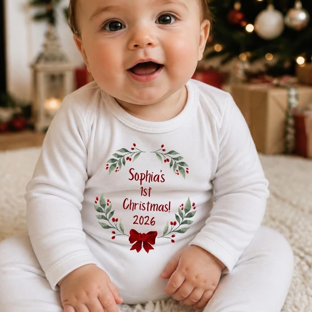Red bow design with holly leaves and berries on a baby grow, vest or bib.
