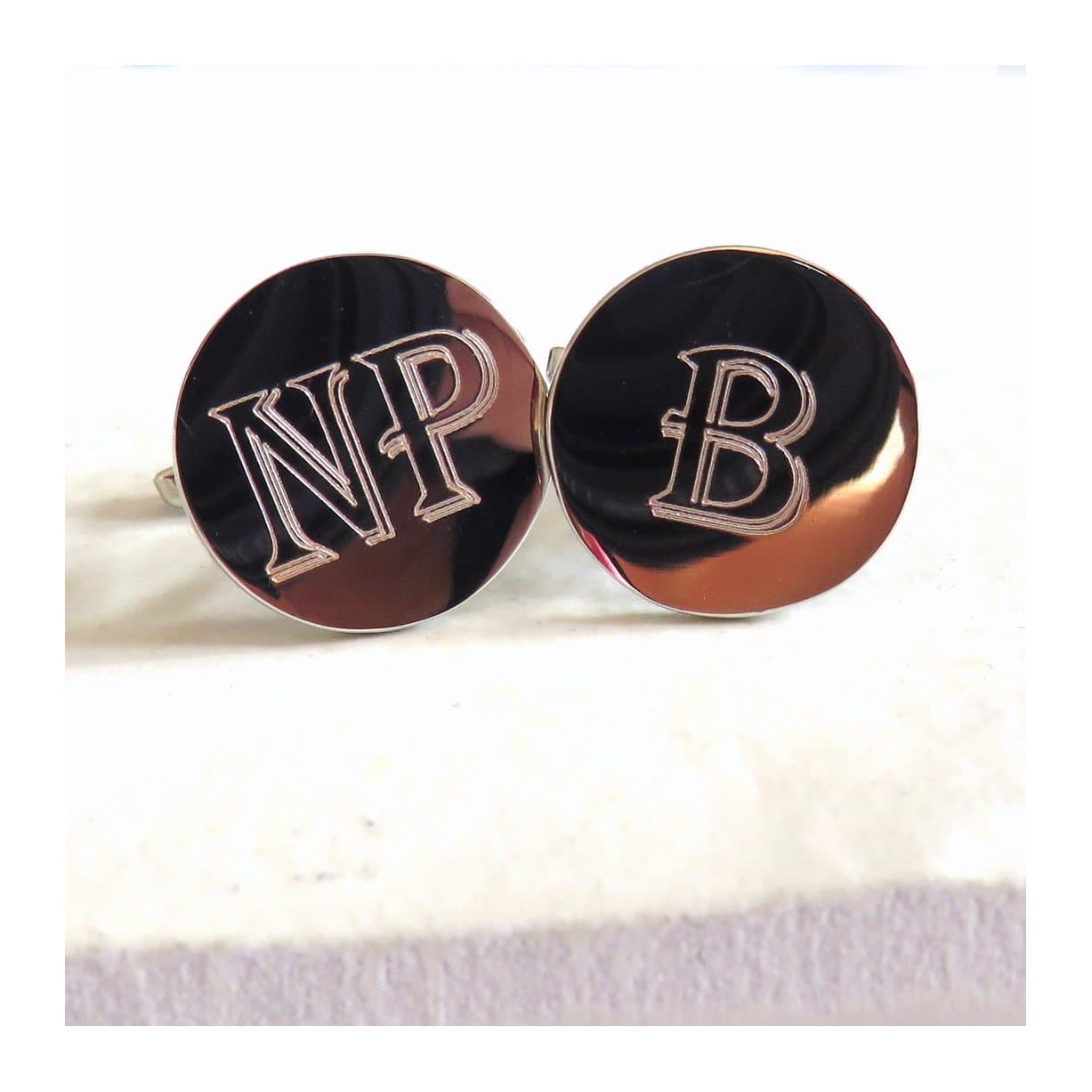 Personalised round cufflink with an engraved initial in bold text