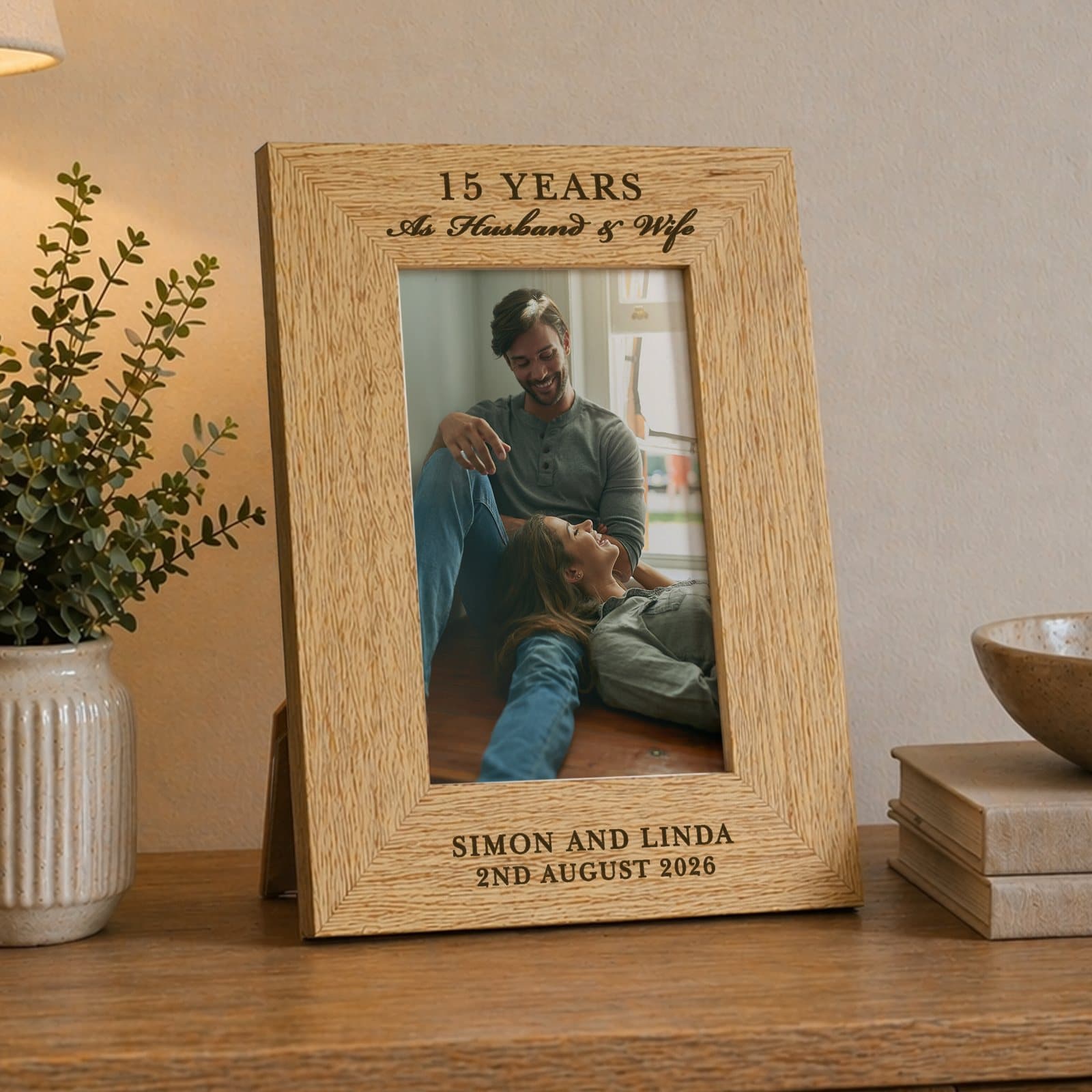 Wooden oak veneer anniversary photo frame with lines of text above and below the photo