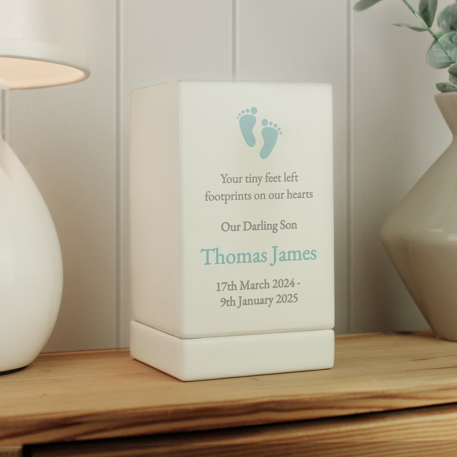 Small wooden urn with a blue footprint design and personalised text