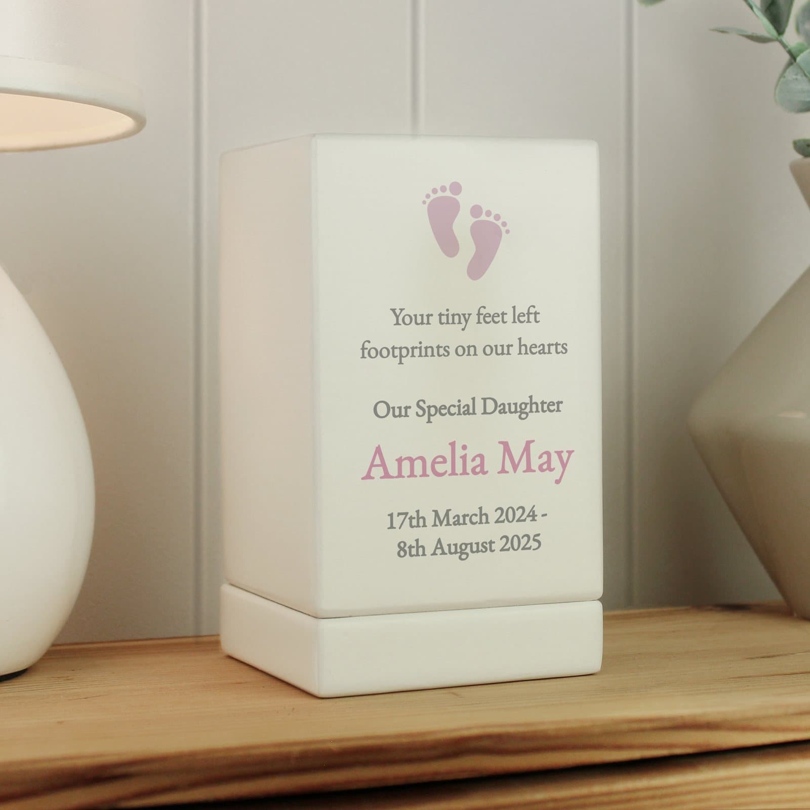 Small wooden urn with a pink footprint design and personalised text