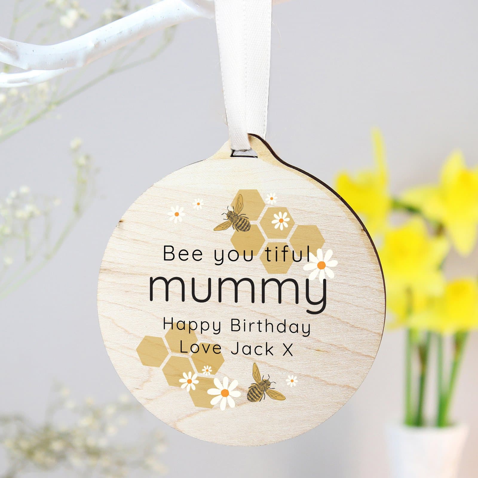 Round wooden bee decoration with personalised lines of text and ribbon