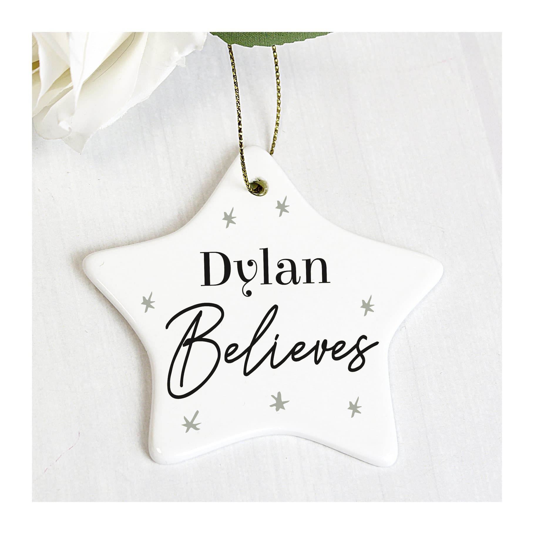 Ceramic star decoration with Believes text, a name and a ribbon
