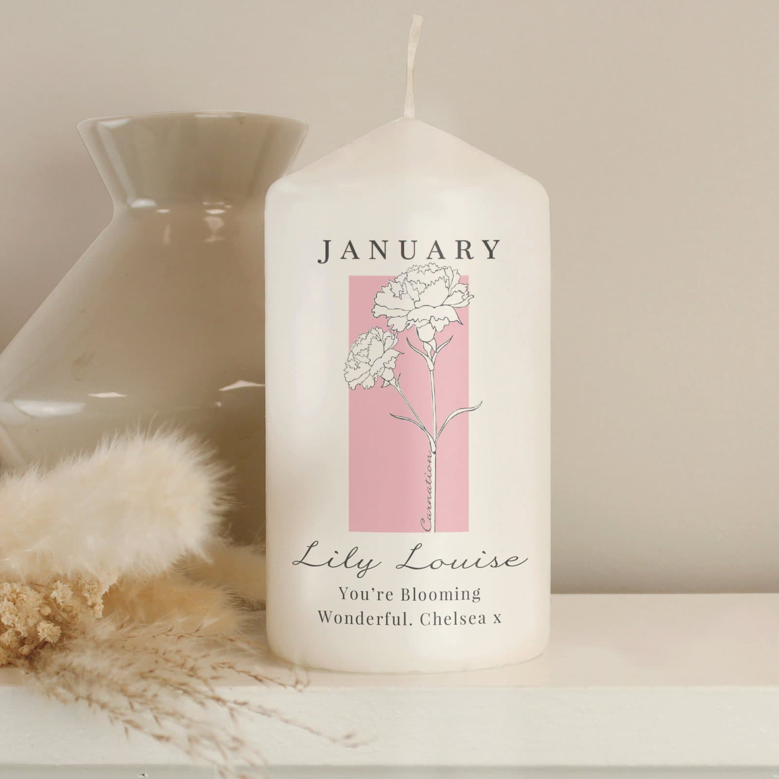 Birth flower pillar candle with a colourful flower illustration, in an organza bag