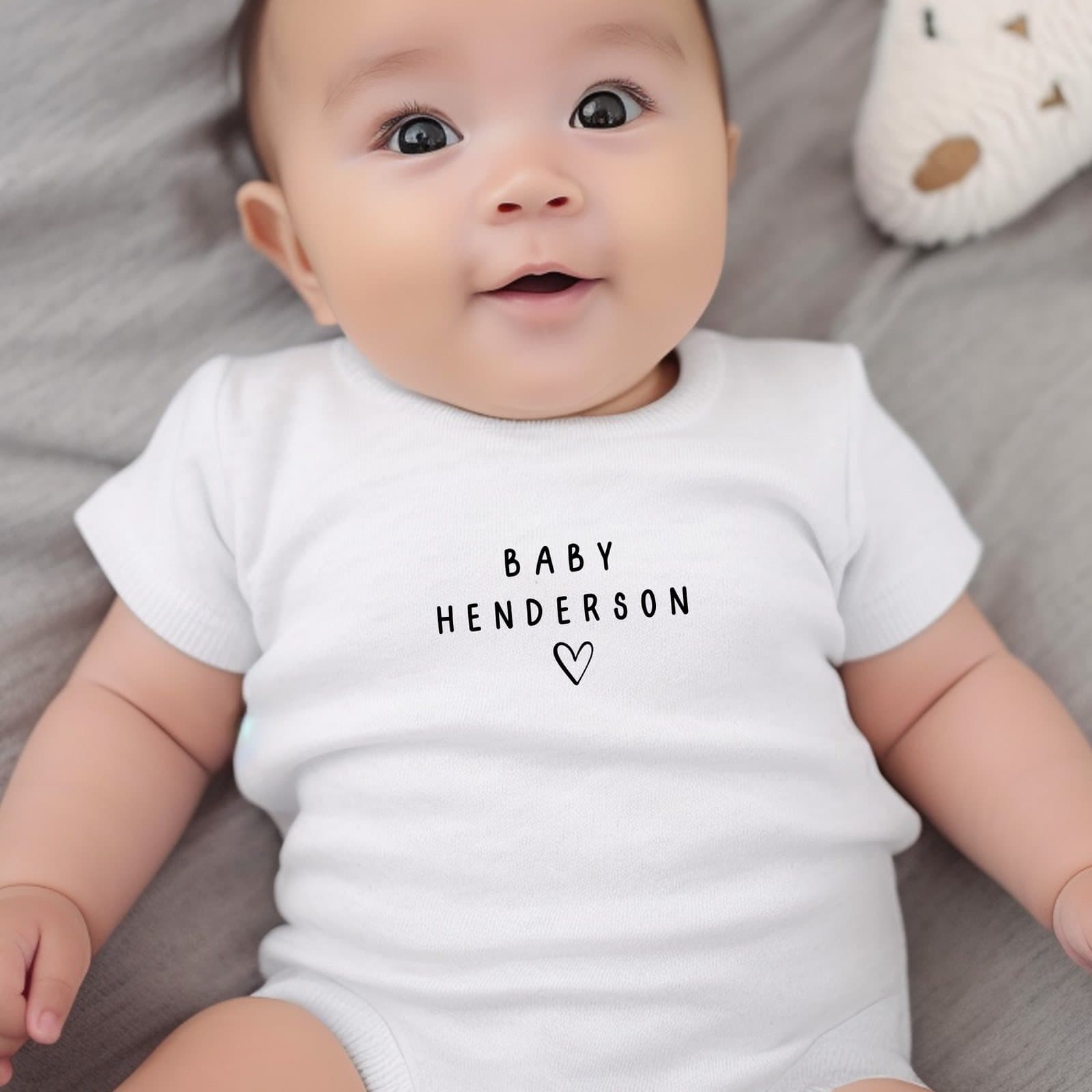 Personalised black surname baby outfit with the name of your choice