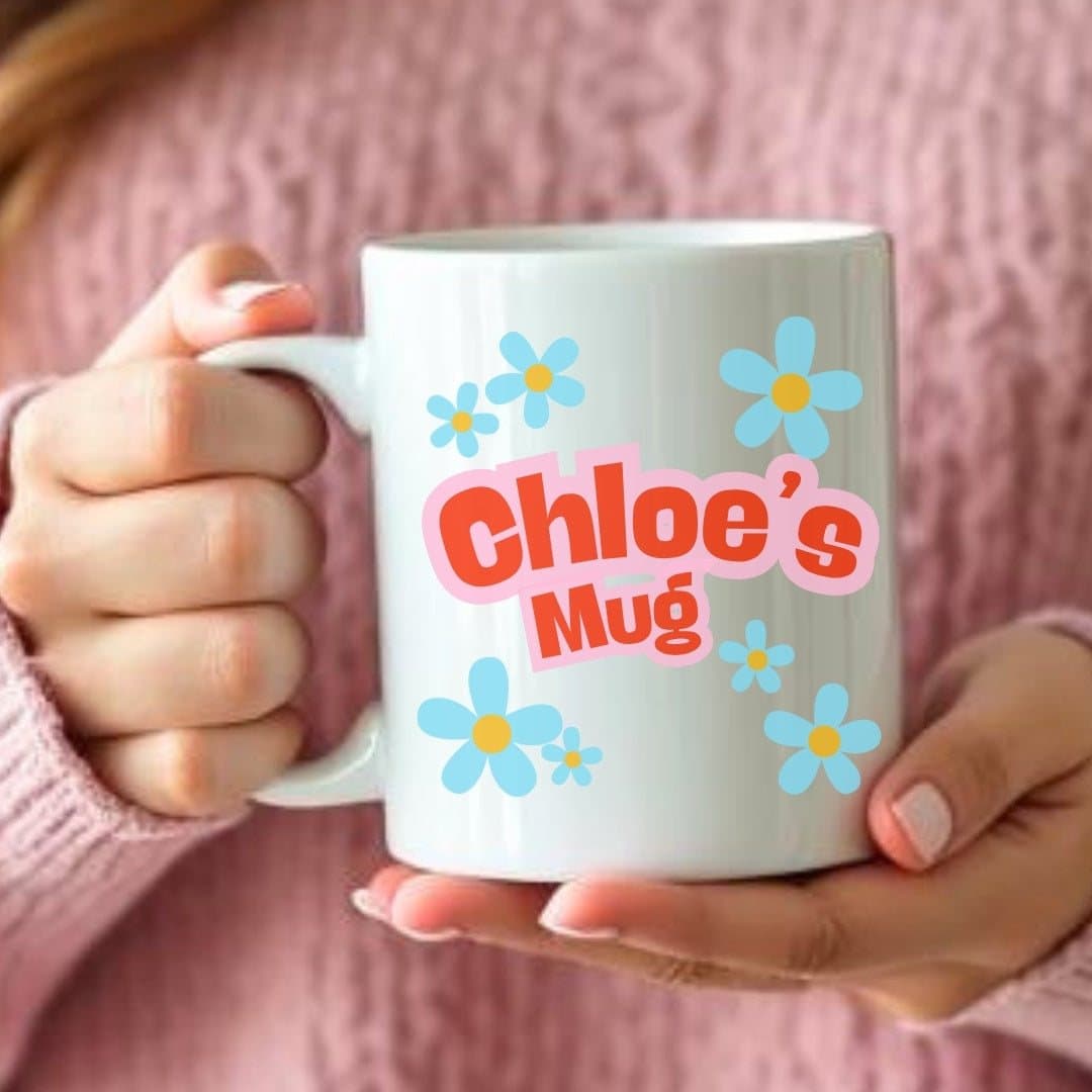 Blue daisy design on a ceramic mug, personalised with a name and initial