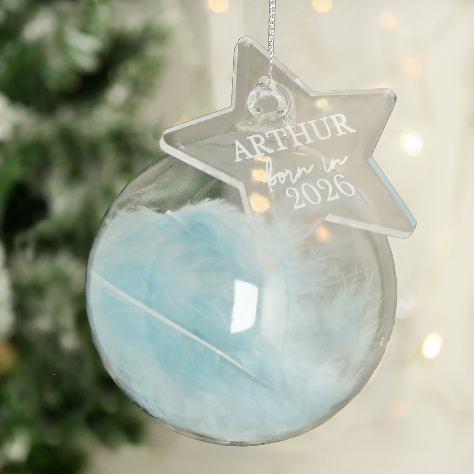 Glass bauble filled with a blue feather and an acrylic star tag