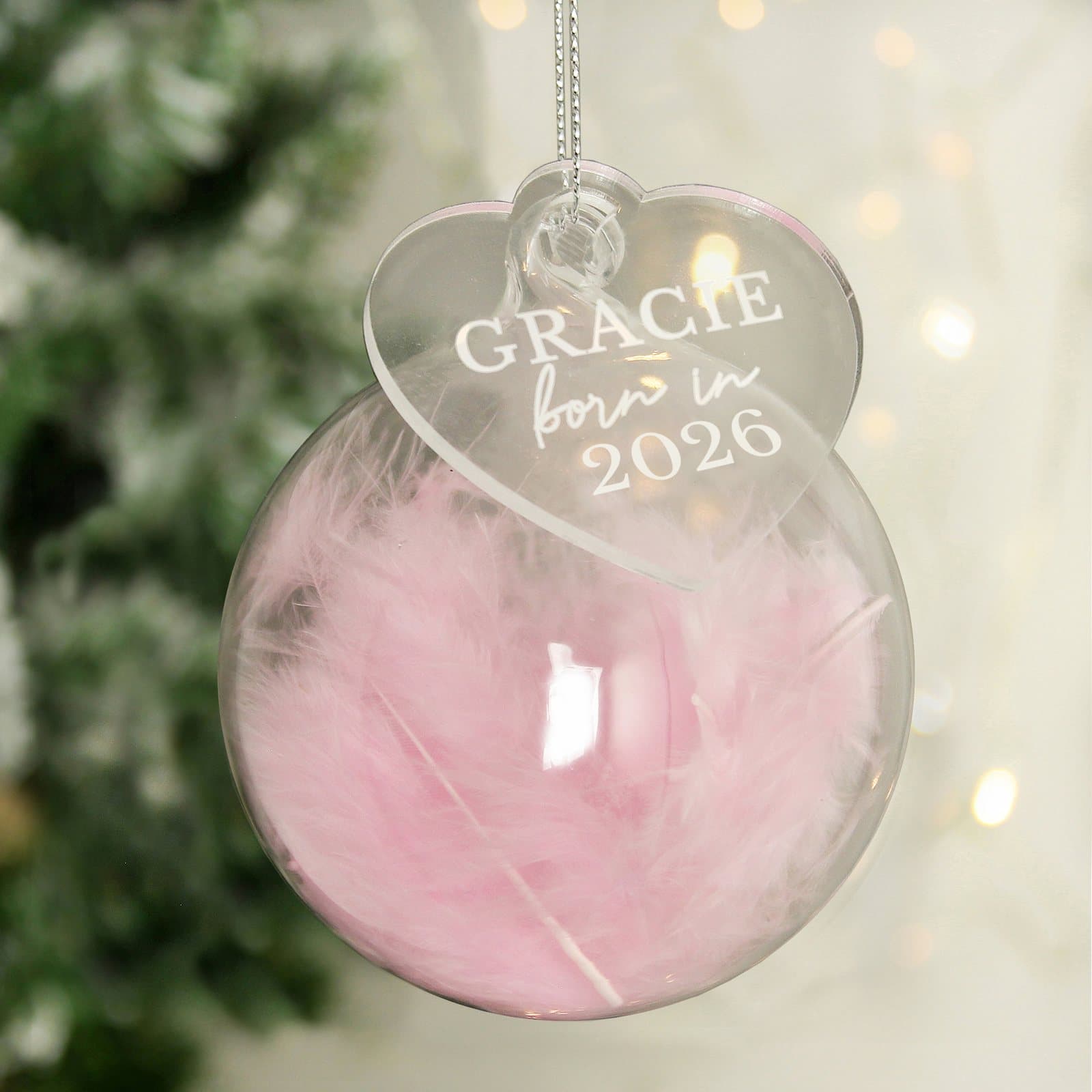 Pink feather glass bauble with an acrylic heart tag reading Born In