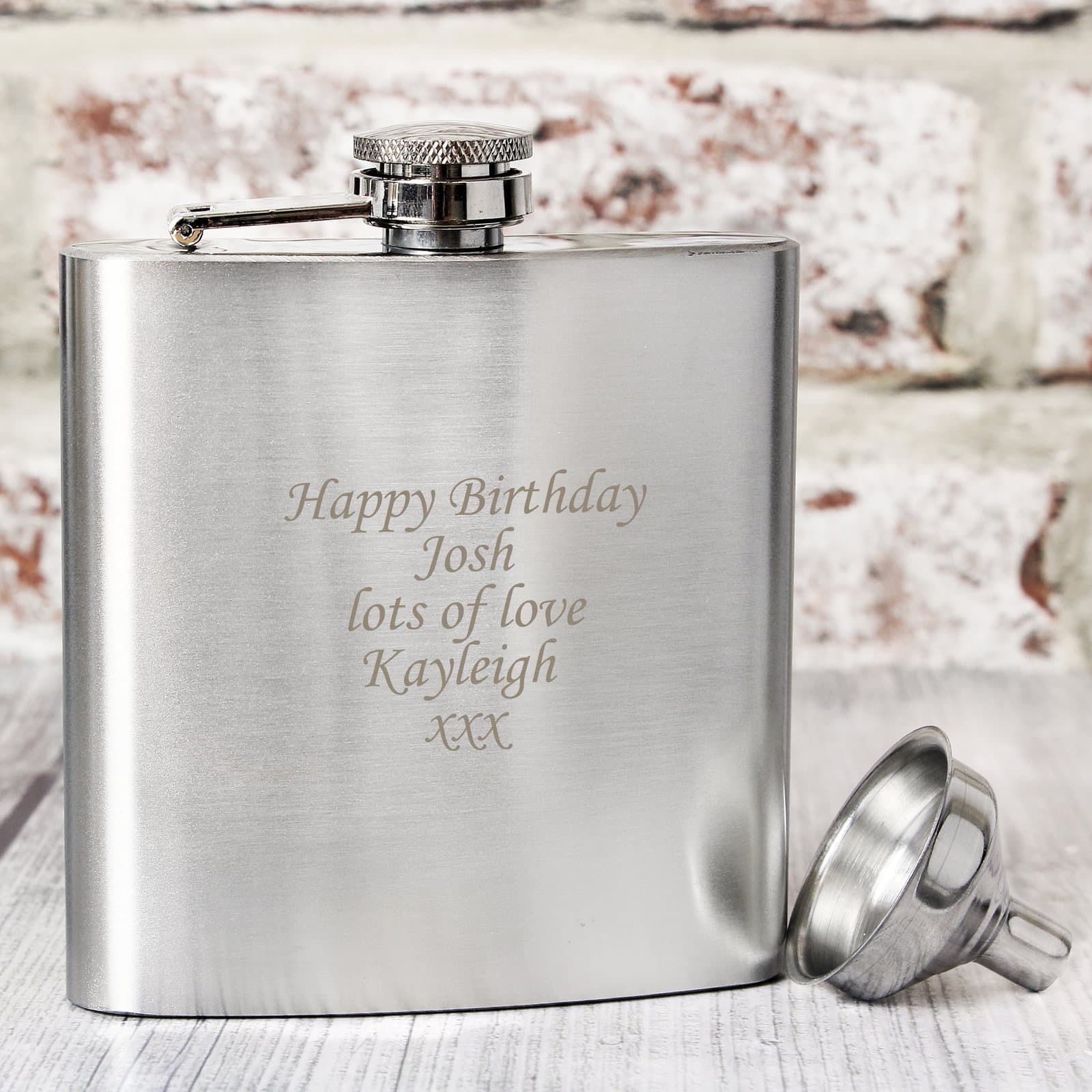 Stainless steel hip flask engraved with a personalised message beside its presentation box