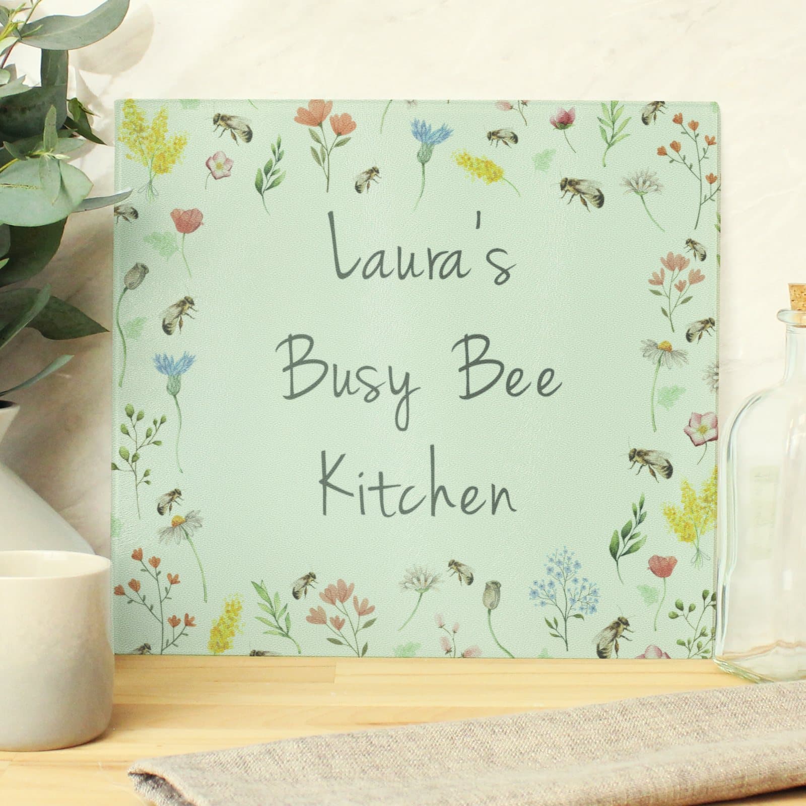 Glass chopping board and worktop saver with a personalised busy bee design