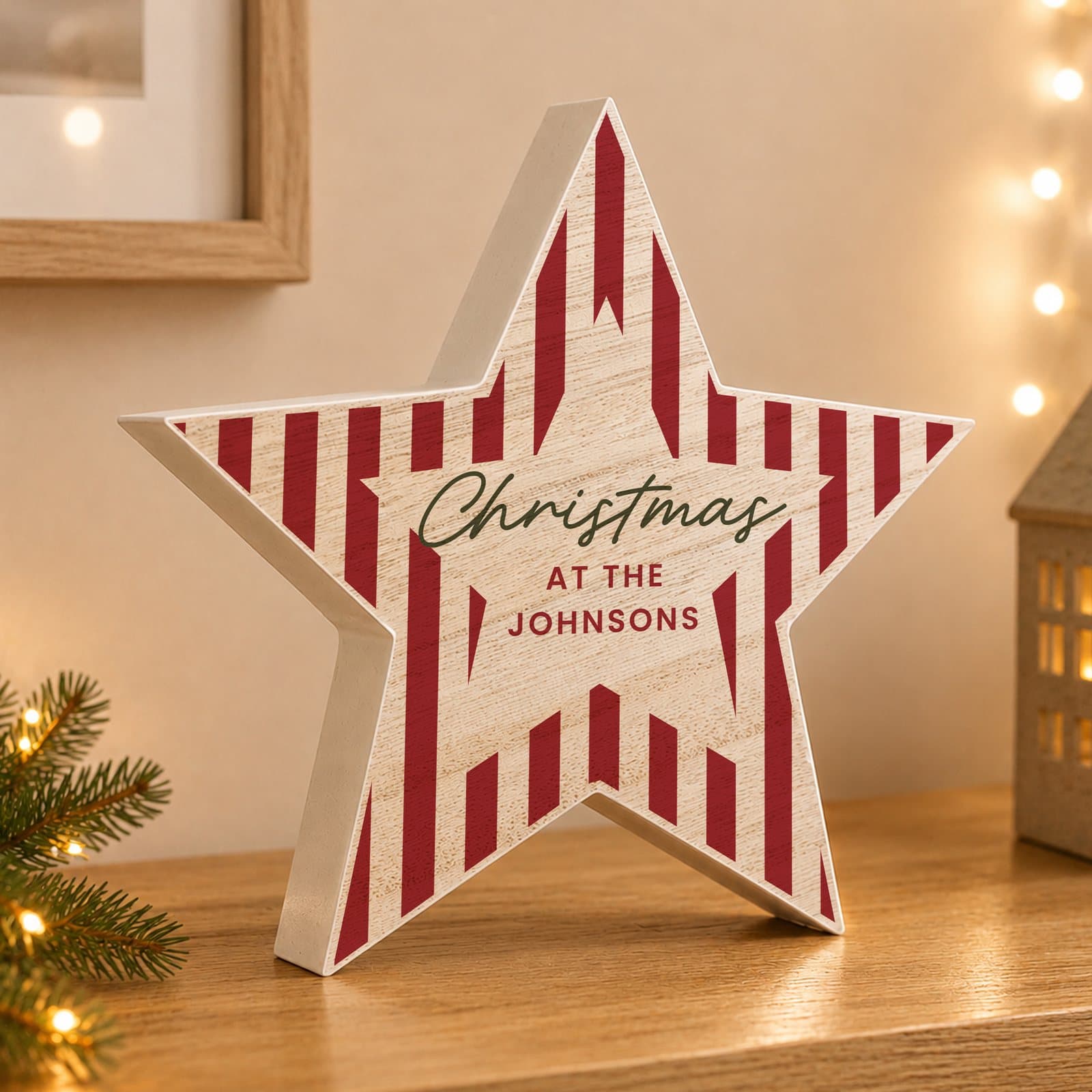 Wooden star ornament with a candy cane stripe design and three lines of personalised text