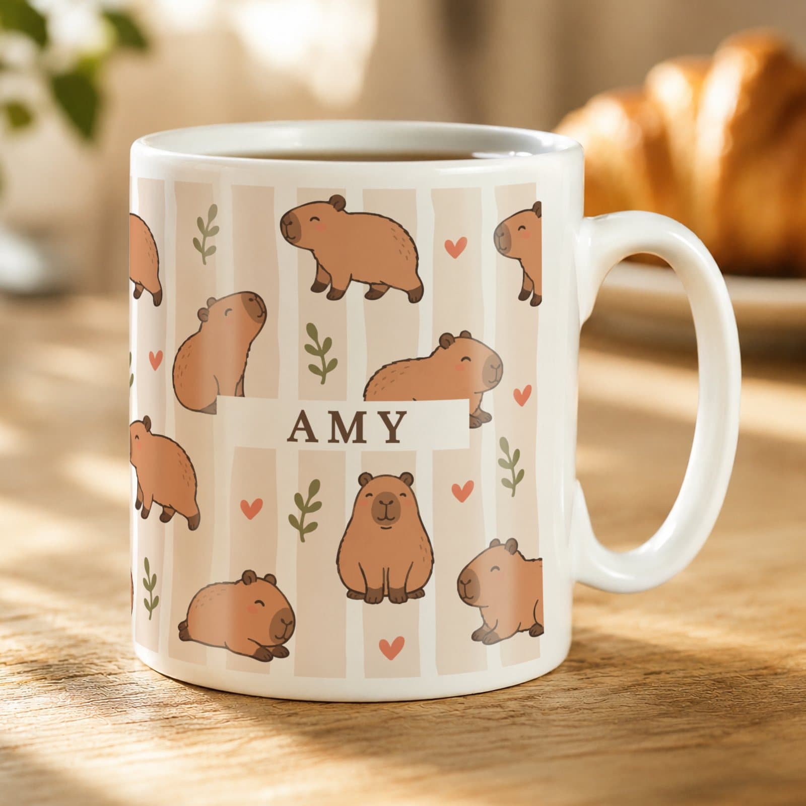 Ceramic mug with a capybara design and a personalised name in capitals