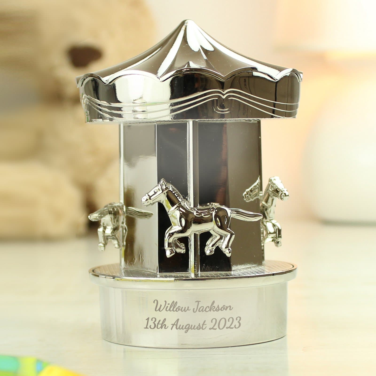 Silver plated carousel money box with a message around the base