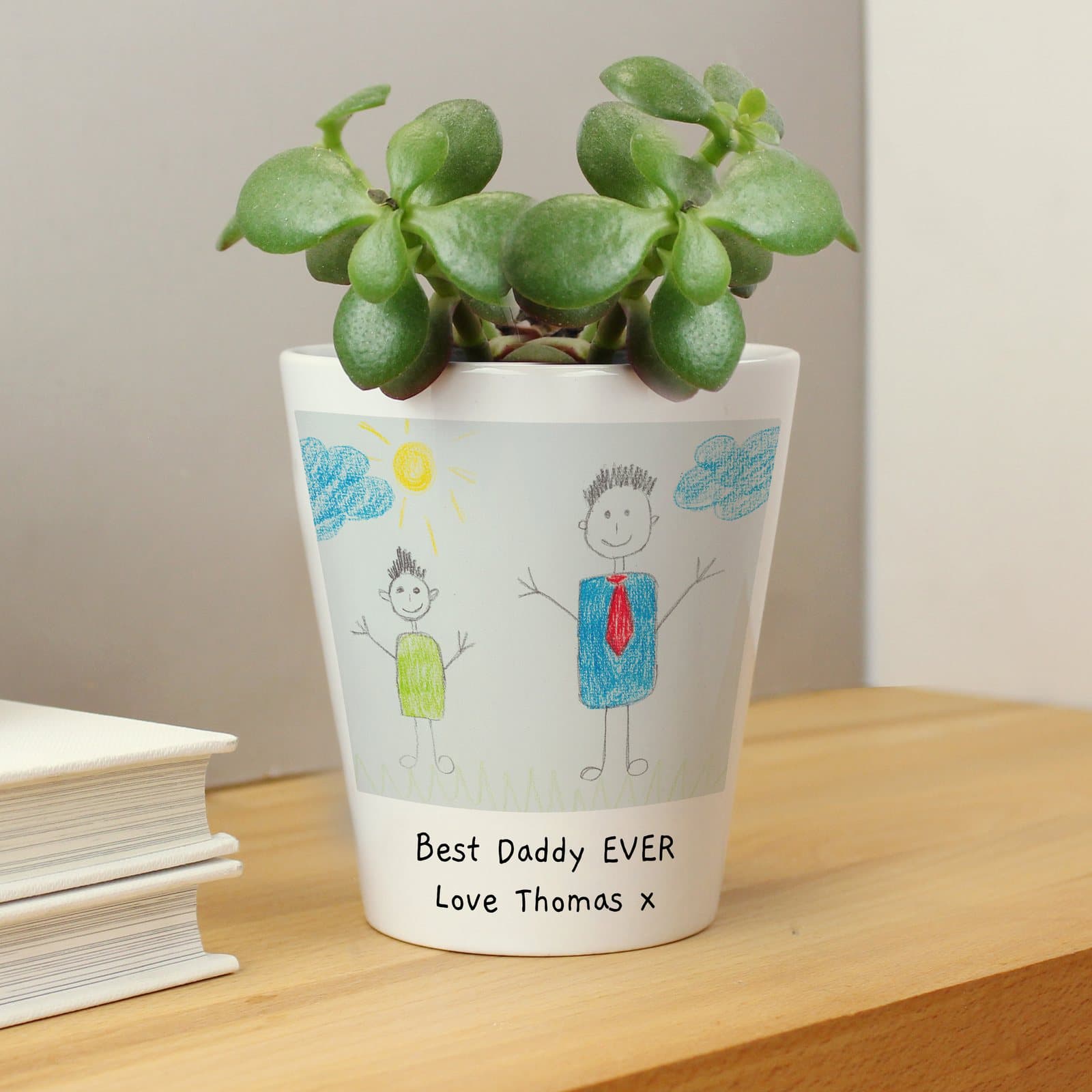 Ceramic plant pot printed with a child's drawing and two lines of personalised text