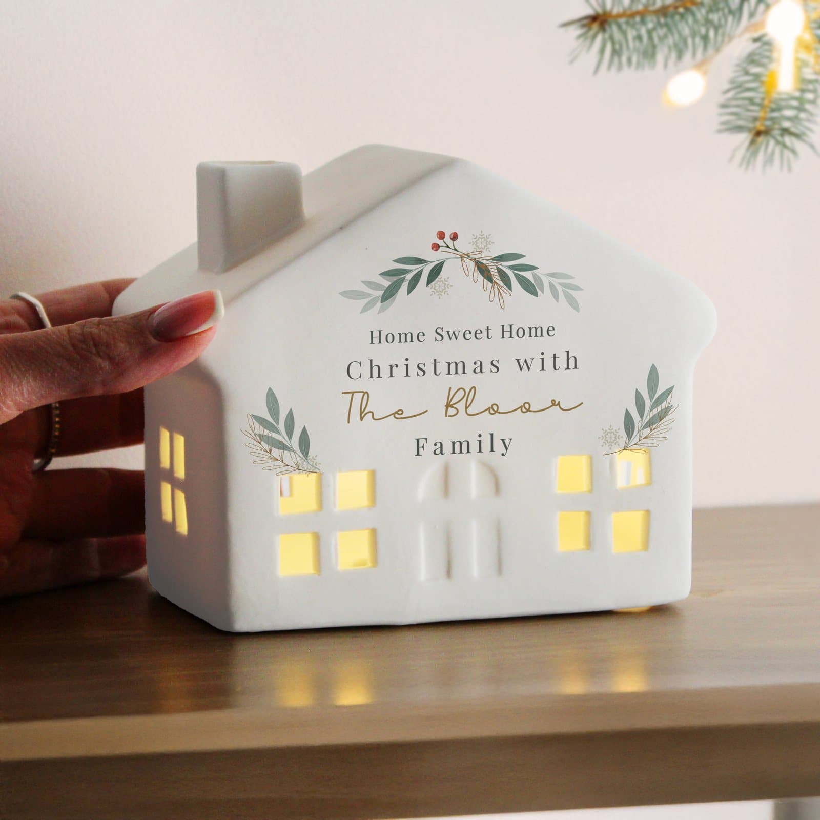 Ceramic Christmas house with cut-out windows lit by LED and personalised message lines