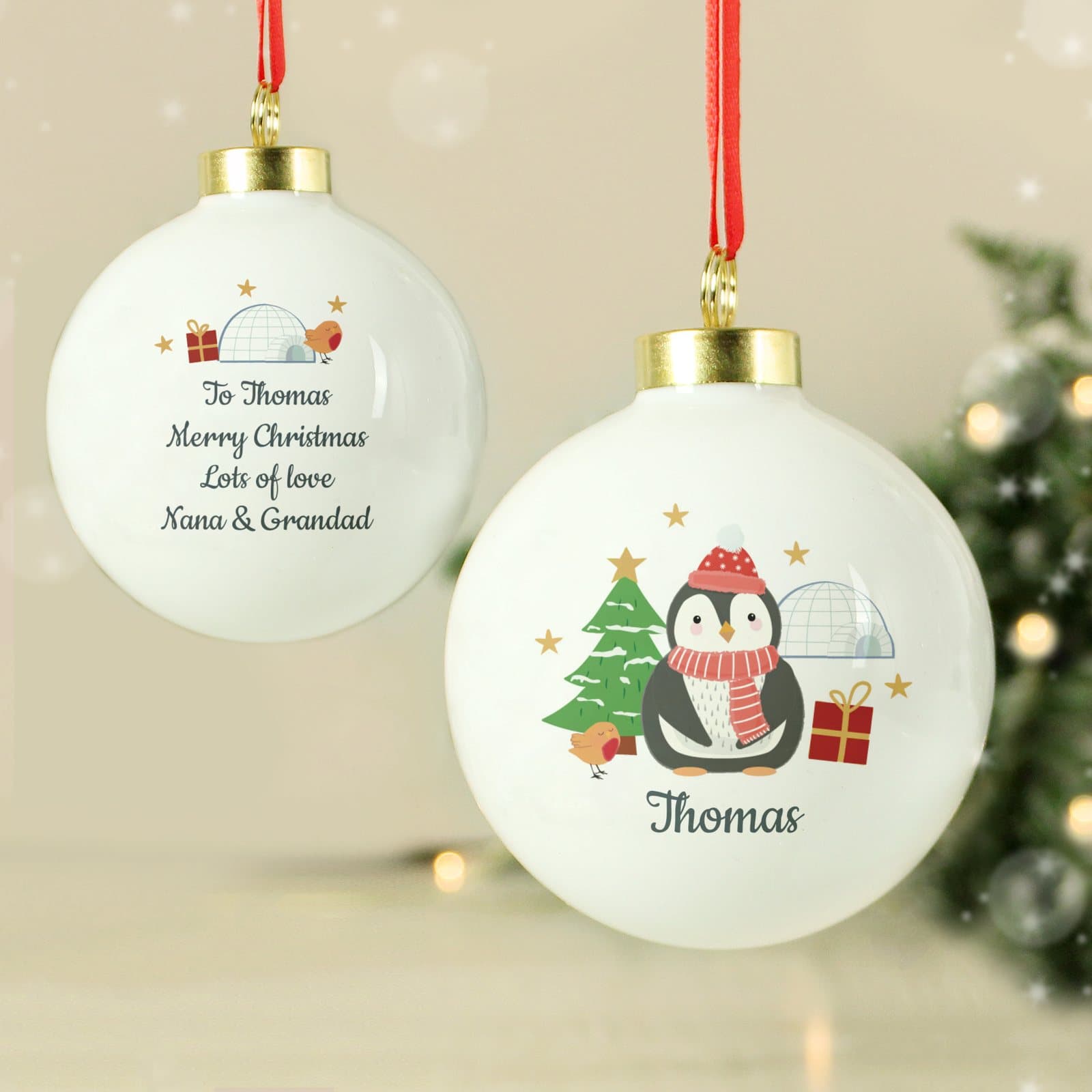 Christmas bauble with a penguin design, a personalised name and a hanging ribbon