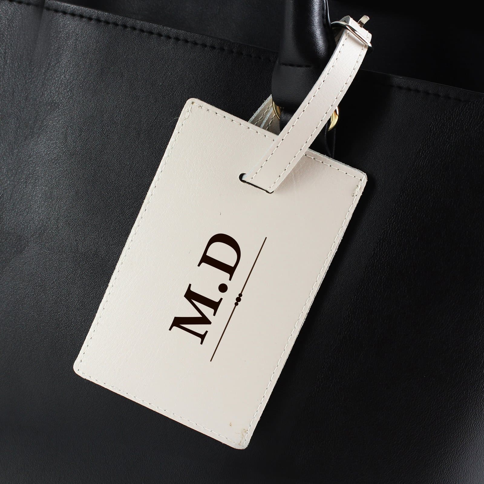 Cream leather luggage tag with a buckle and initials