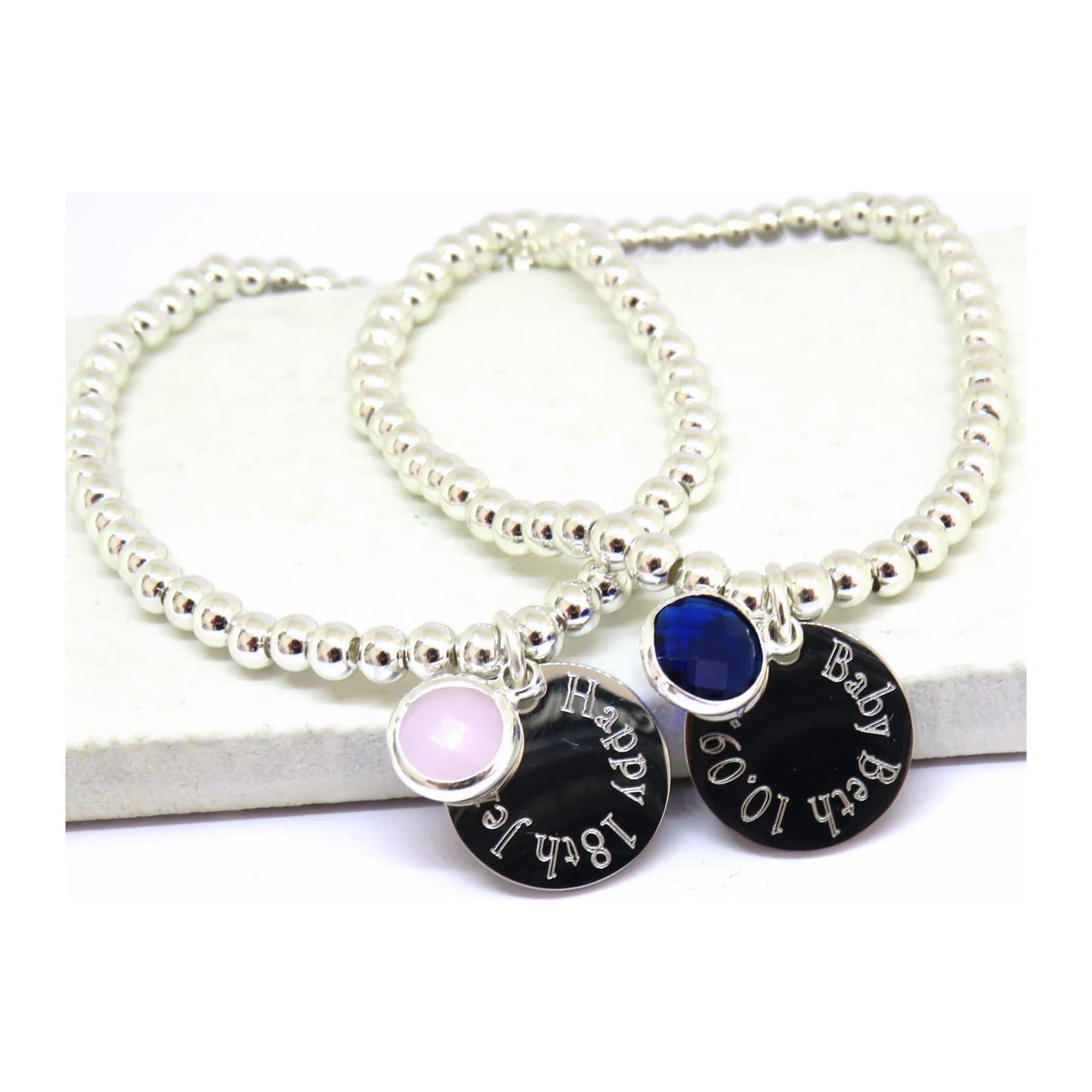 Silver-coloured beaded stretch bracelet with an engraved round charm