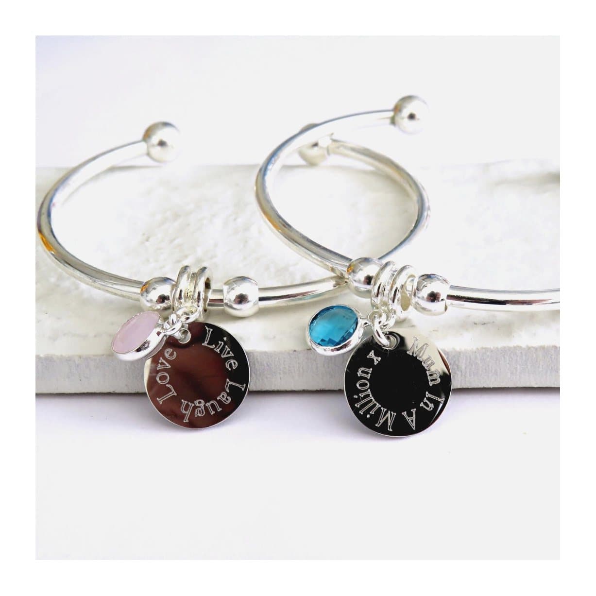 Engraved steel charm and faceted birthstone charm on a torque bangle
