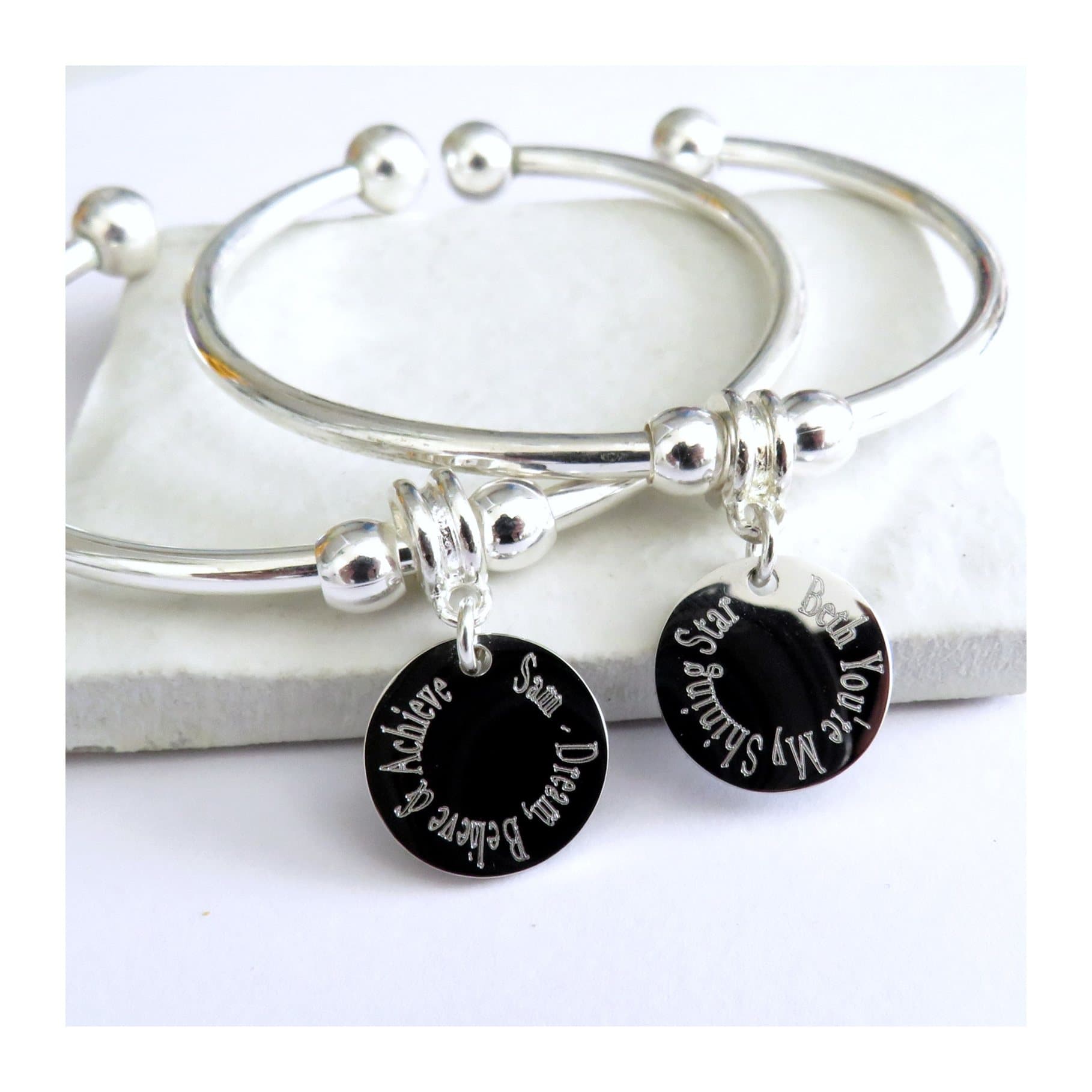 Personalised charm torque bangle with a round silver coloured charm