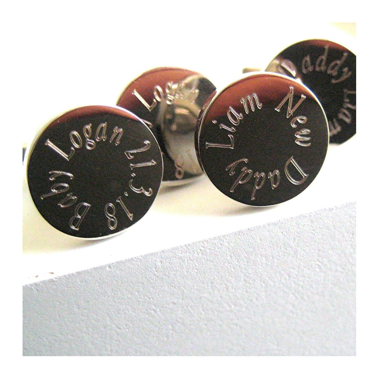Round silver cufflinks with a name engraved around the edge