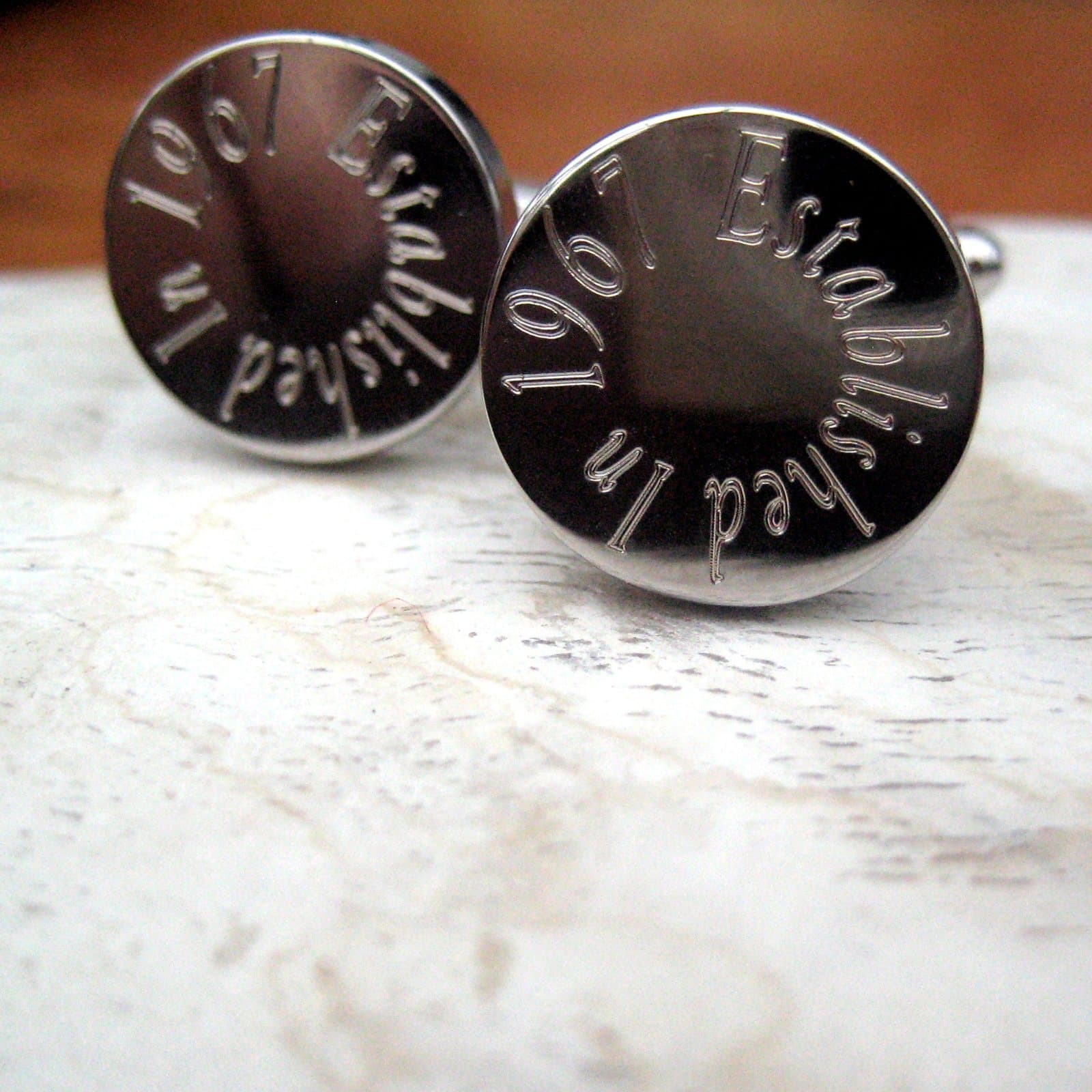 Round silver-coloured personalised cufflinks engraved with a name