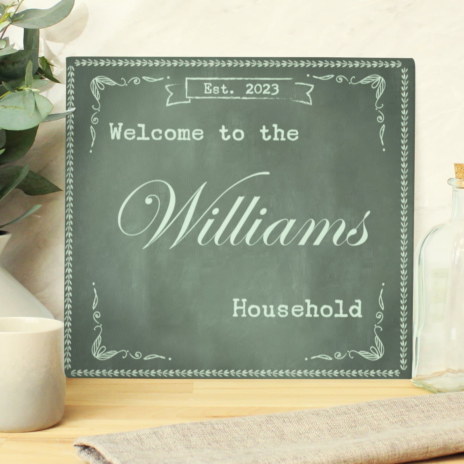 Glass chopping board and worktop saver with a banner and lines of personalised text