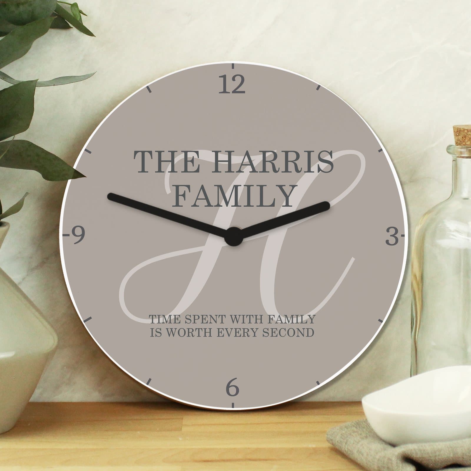 Square white wood family clock with an initial and lines of text