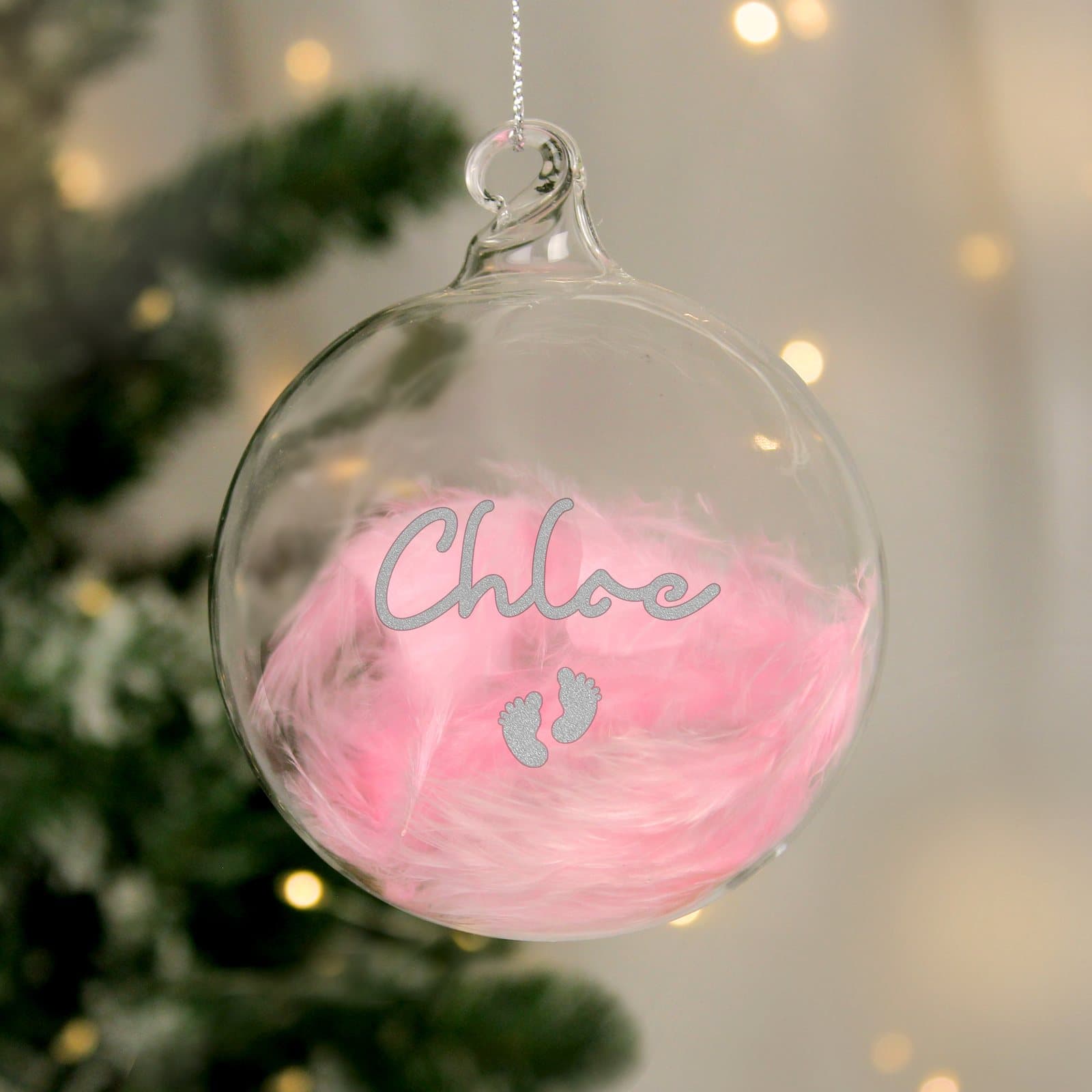 Glass bauble with a feather and silver footprints under a name
