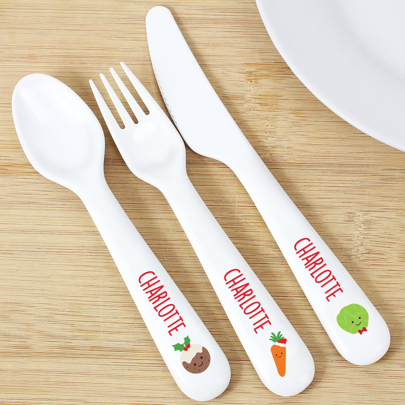 Plastic spoon, fork and knife with sprout, carrot and Christmas pudding motifs