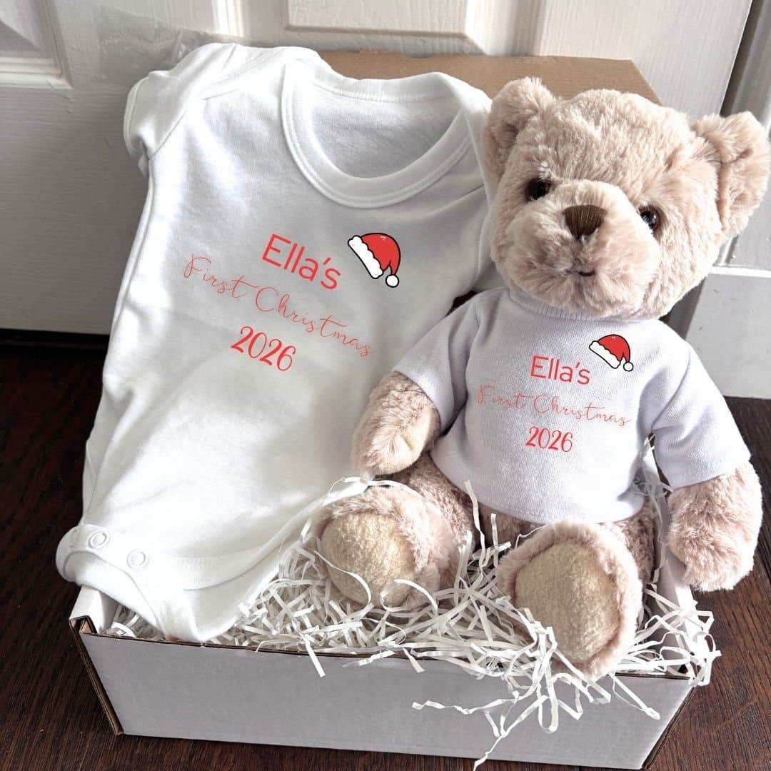 Teddy bear and baby vest with a First Christmas Santa hat design, in a white box