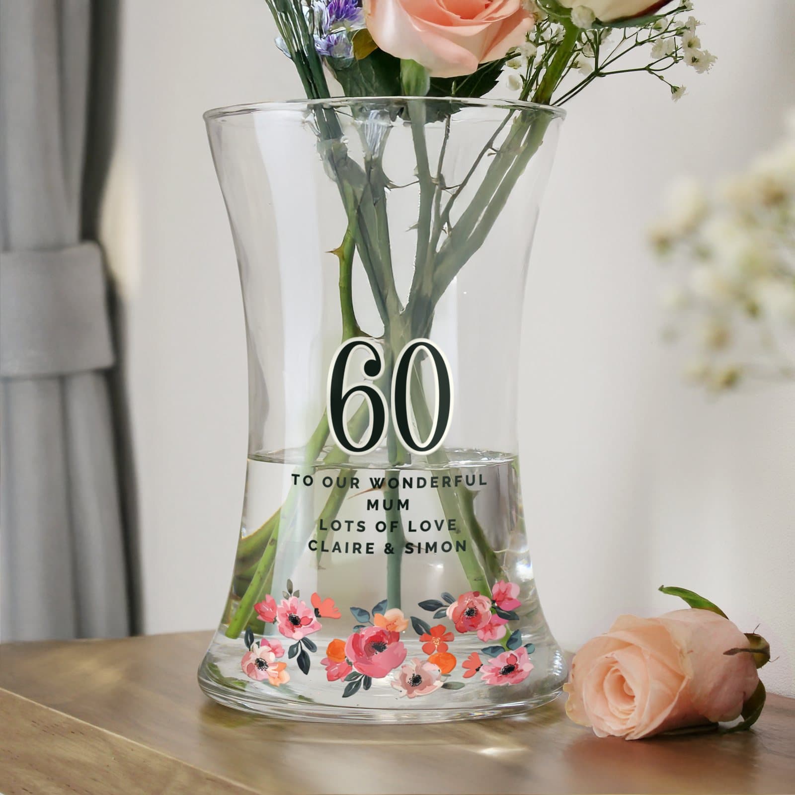 Glass waisted floral vase with a big age and text