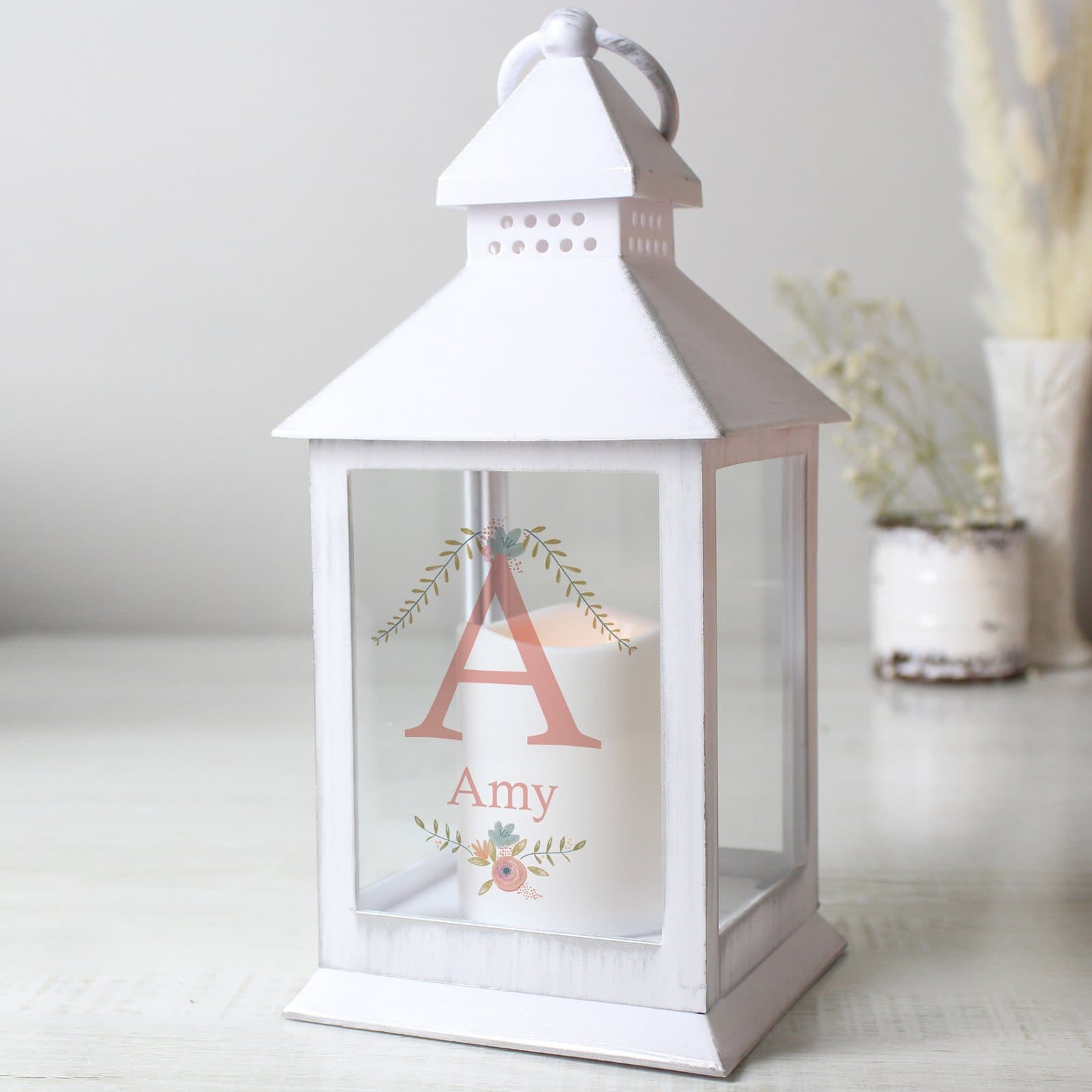 White lantern with a floral bouquet design and a warm flame effect