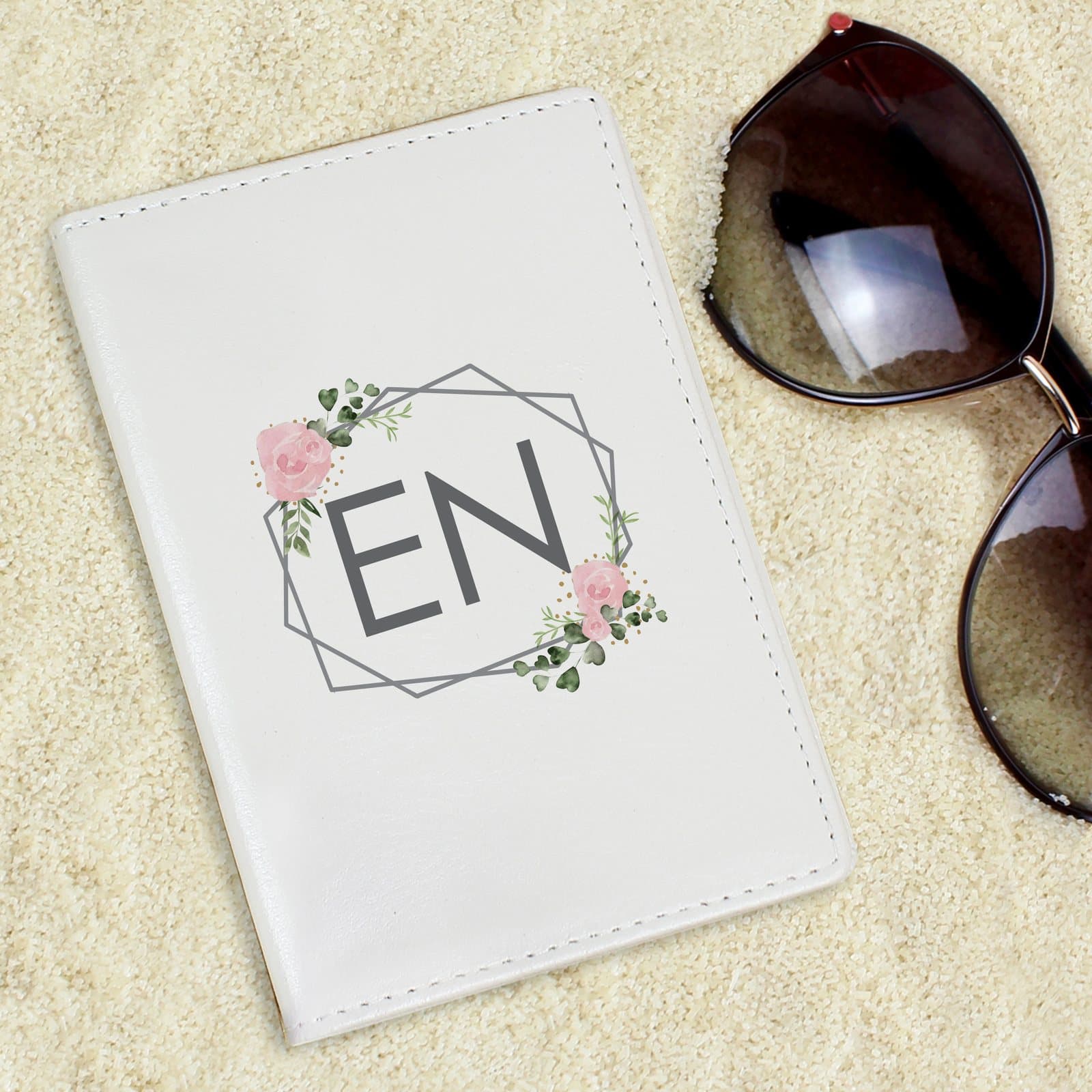 Cream leather passport holder with a floral design and initials